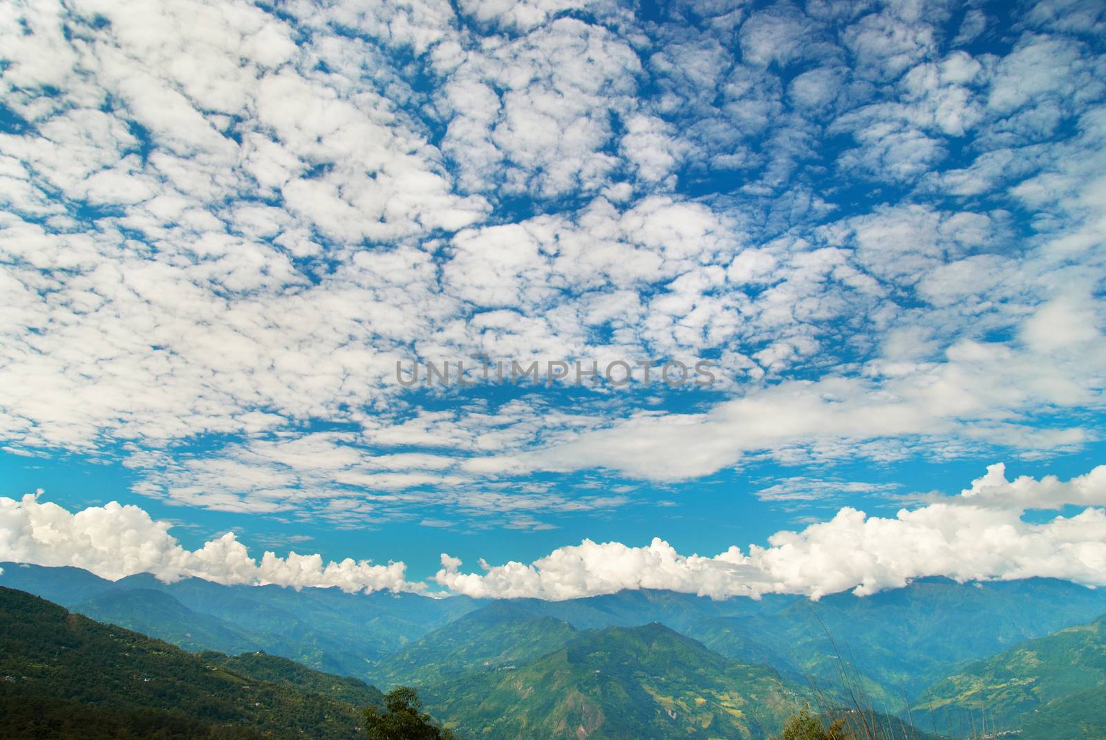 Green mountains with forest and blue cloudy sky