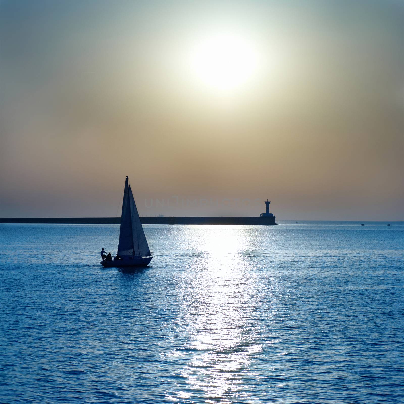 Sail boat against sea sunset. Blue marine landscape.