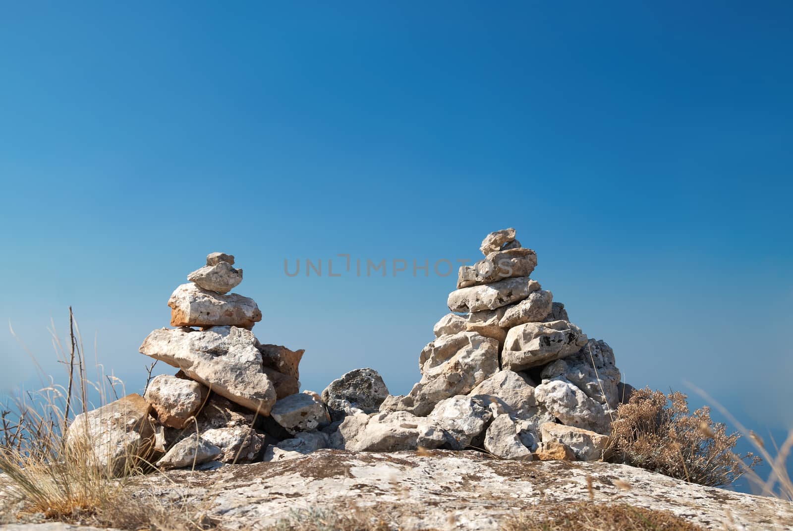 Two stone towers - stacks of zen stones on a blue sky background