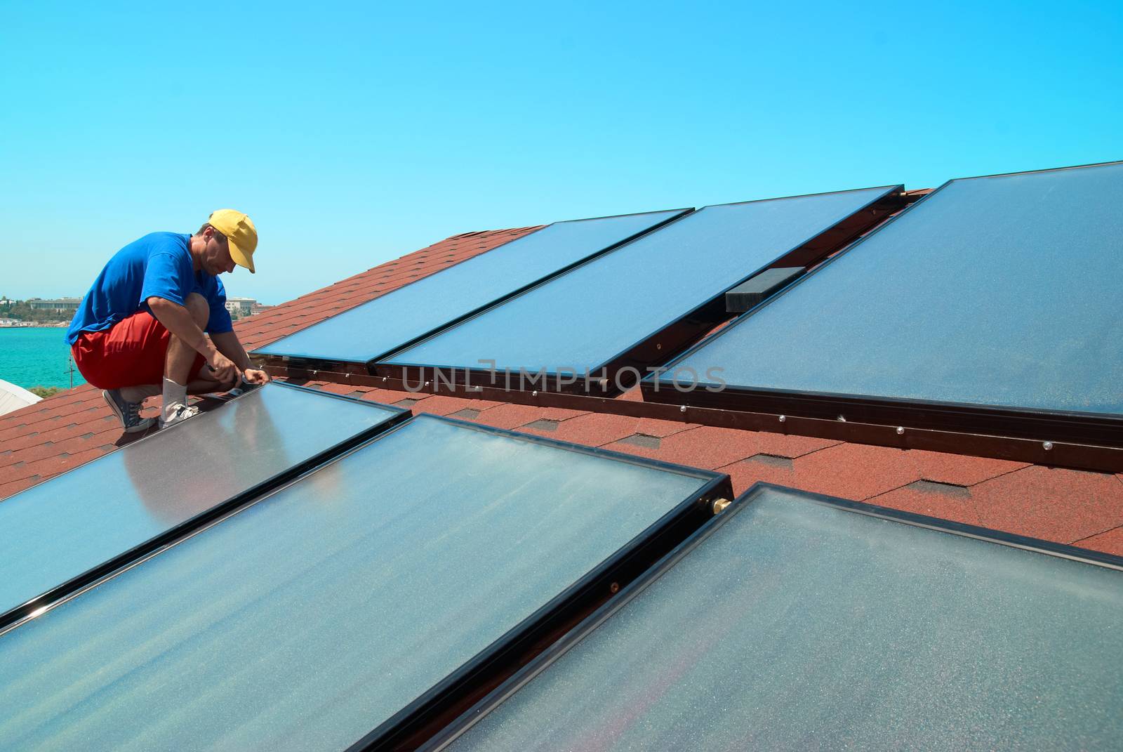 Worker installs solar panels by vapi