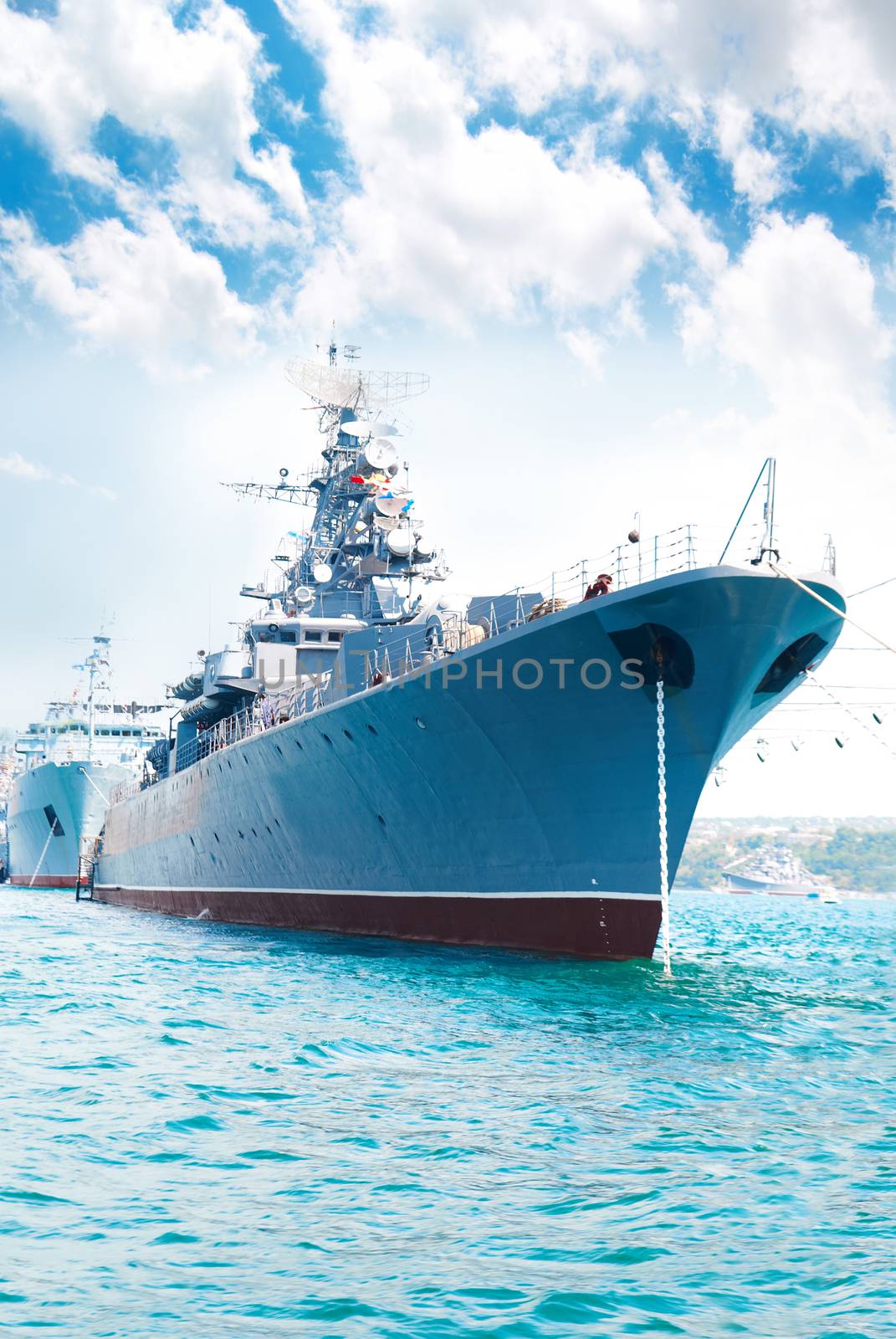 Military navy ship in the bay against blue sky