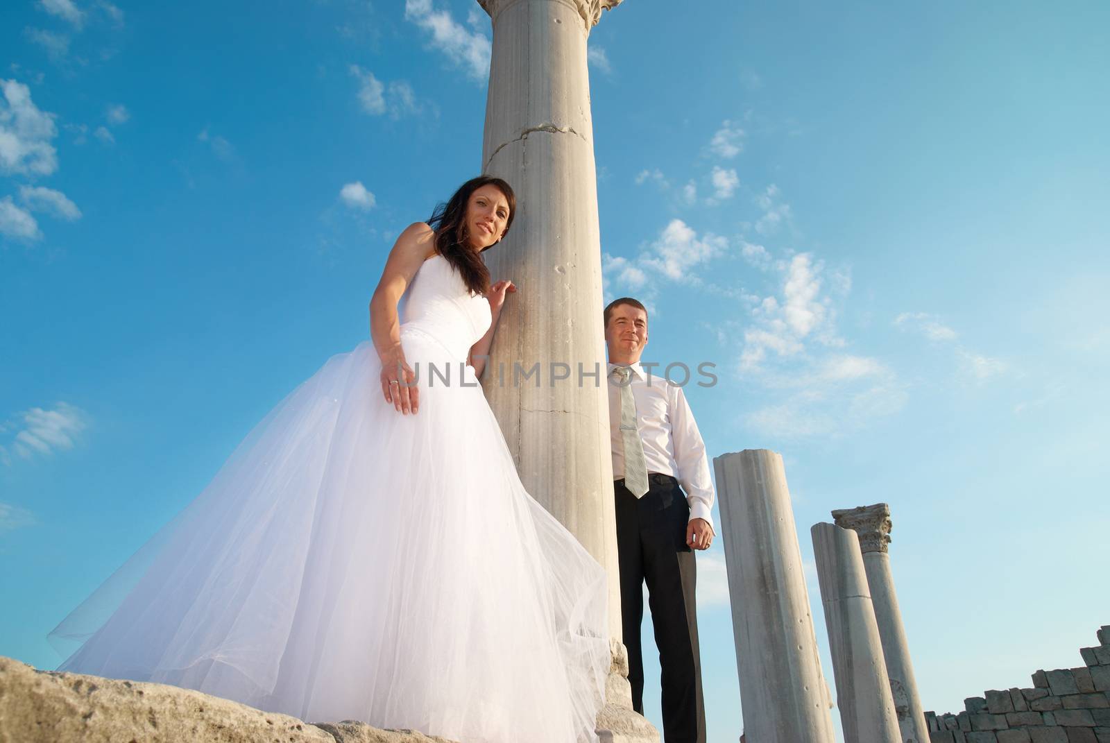 Beautiful wedding couple- bride and groom near greece column in the ancient city