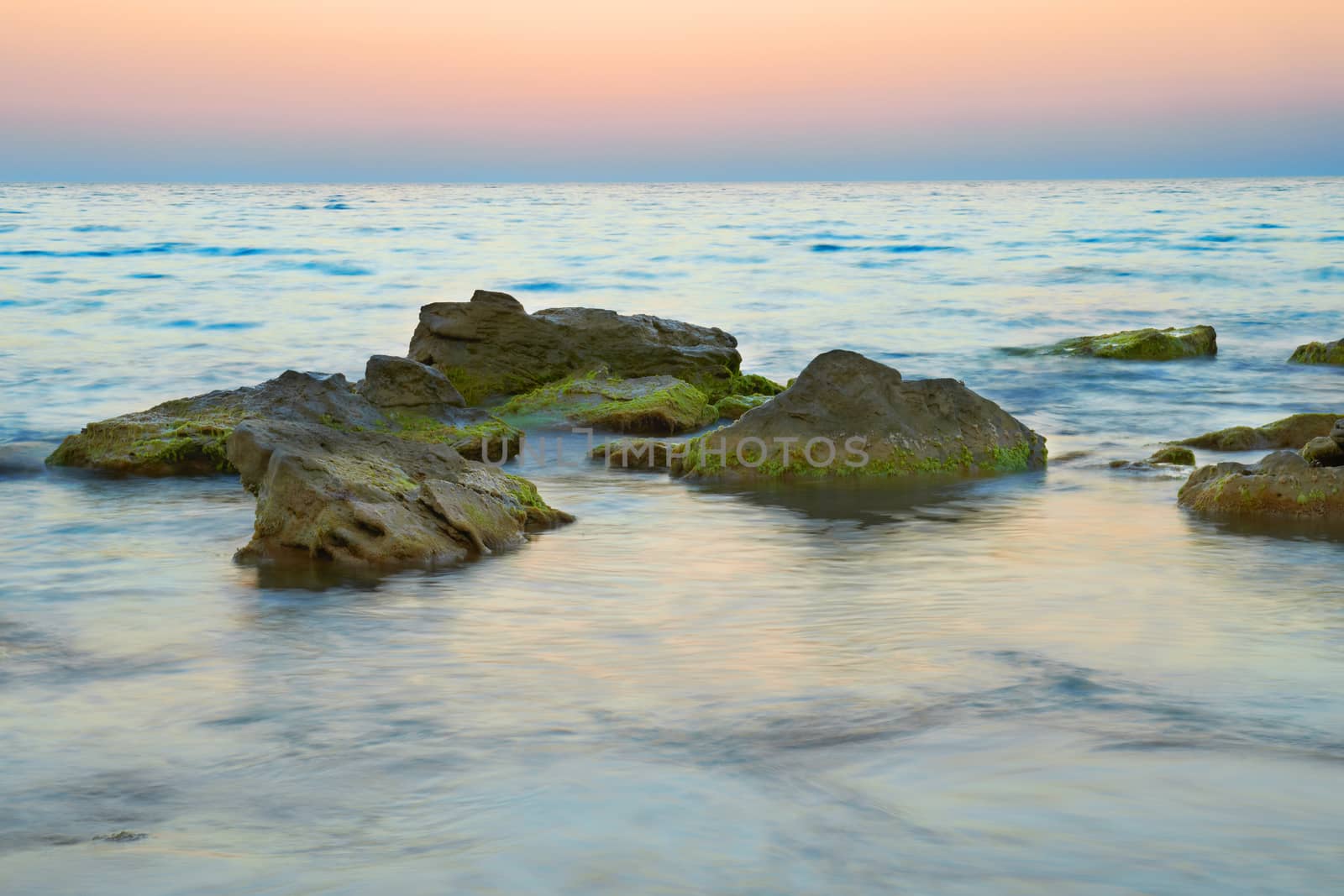 Rocks in the sea against beautiful sunset