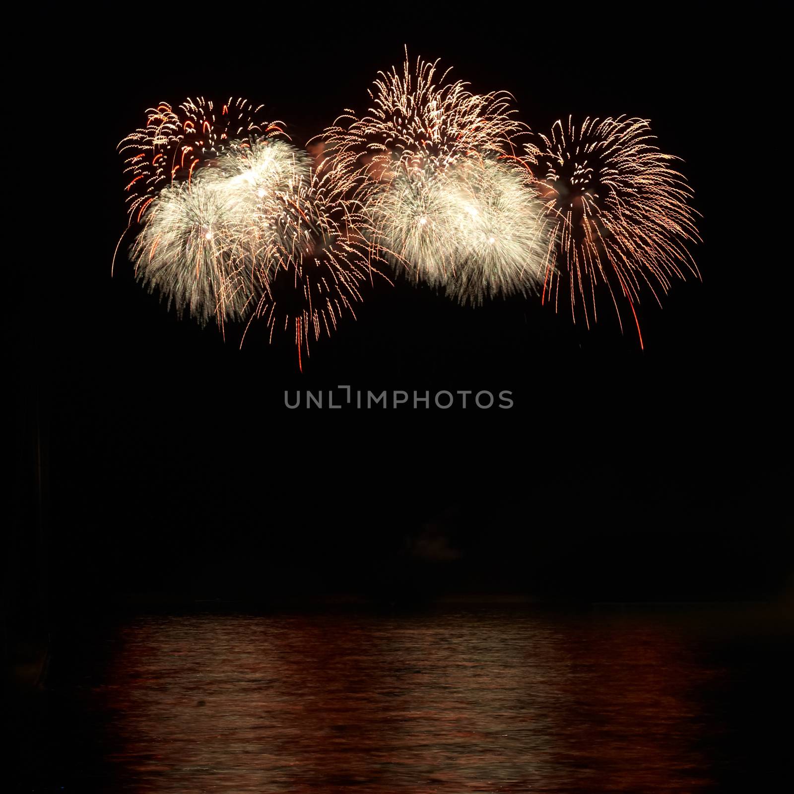 Red colorful holiday fireworks on the black sky background.