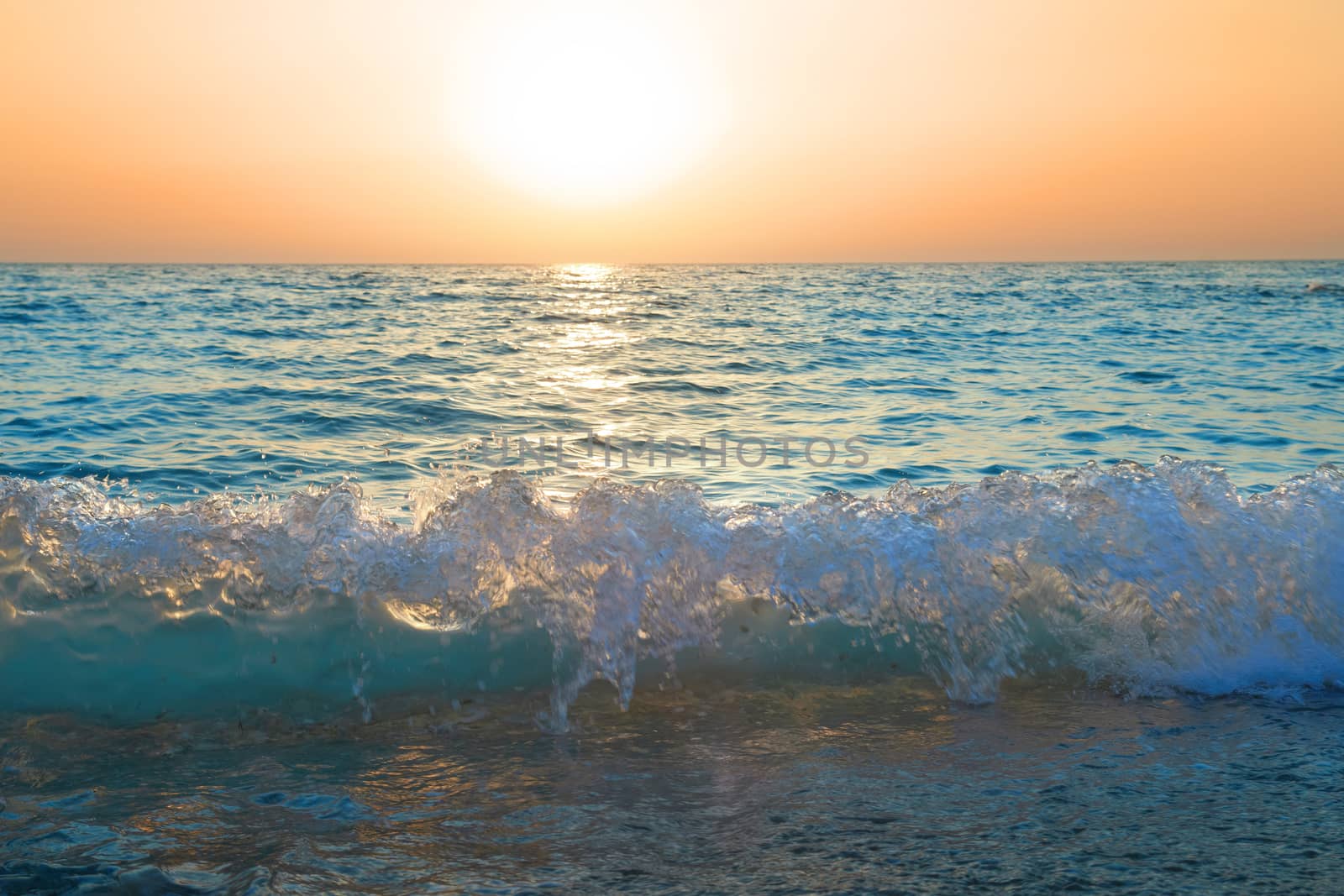 Sunset above the sea. Big sun and waves