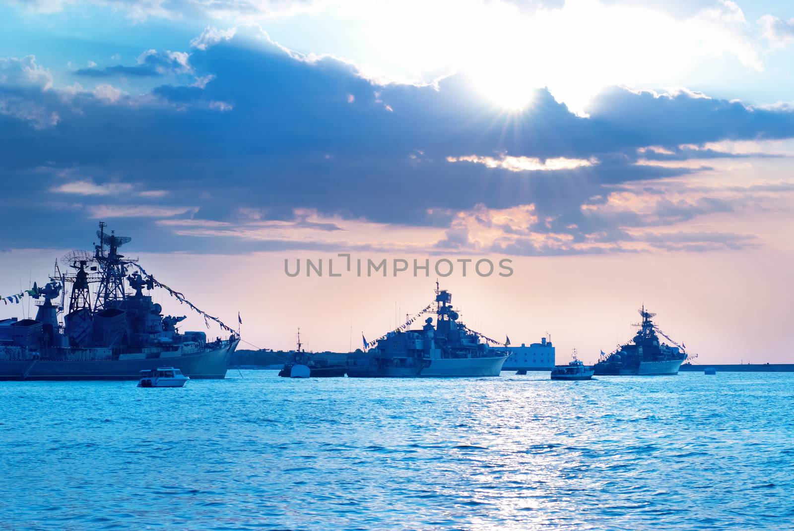 Row of military ships against marine sunset