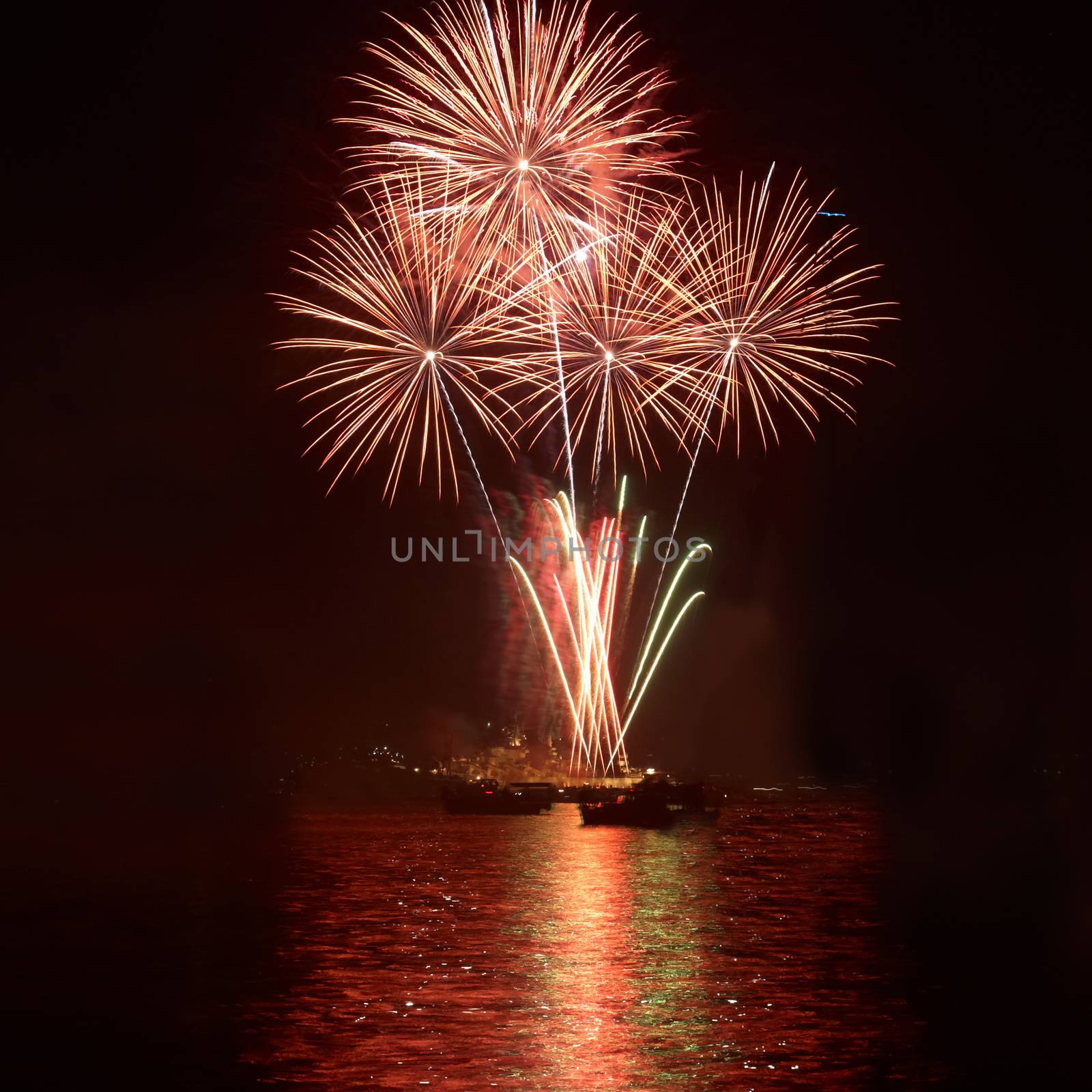 Red colorful holiday fireworks on the black sky background.