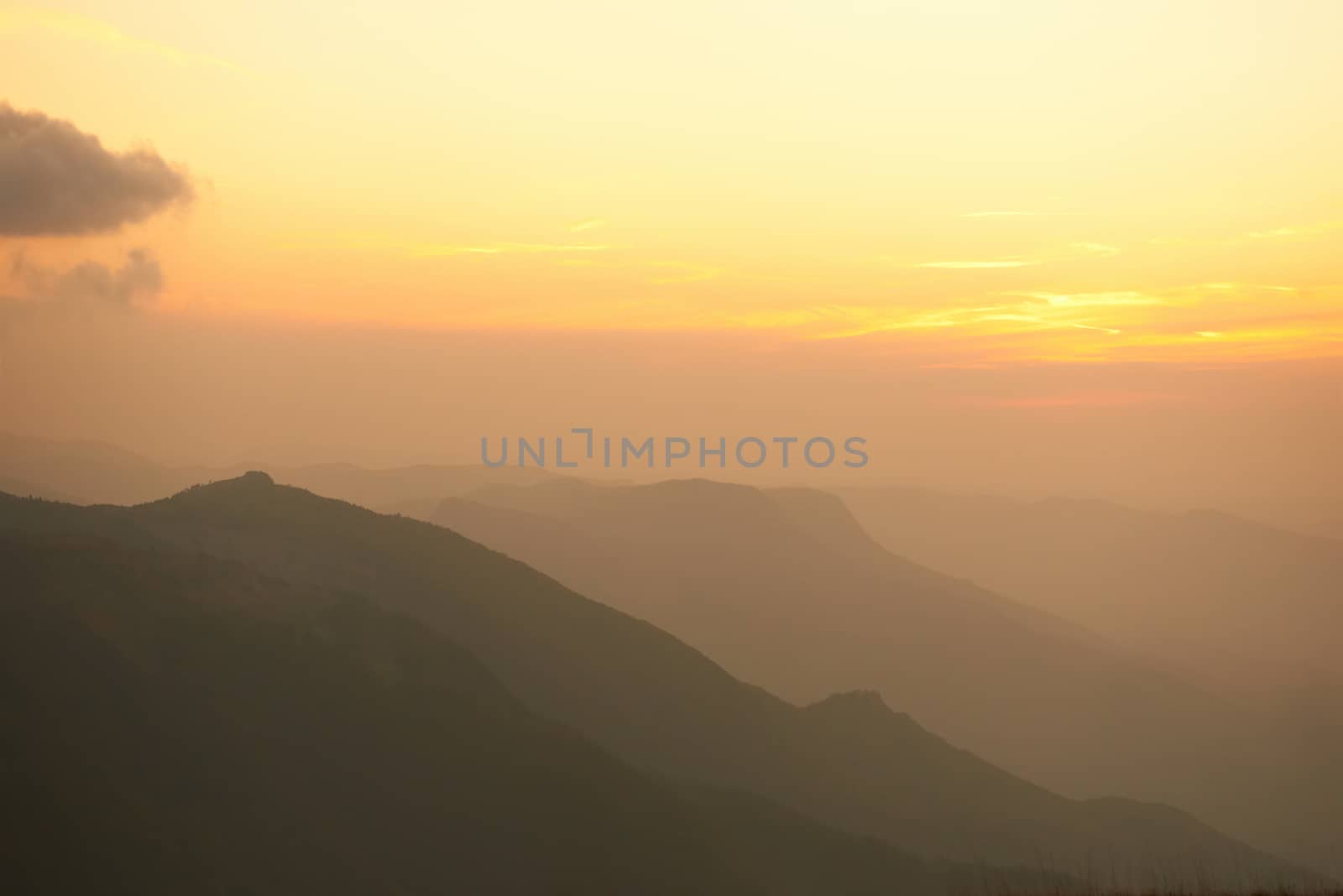 Beautiful sunset at the mountains. Colorful landscape with sun and orange sky