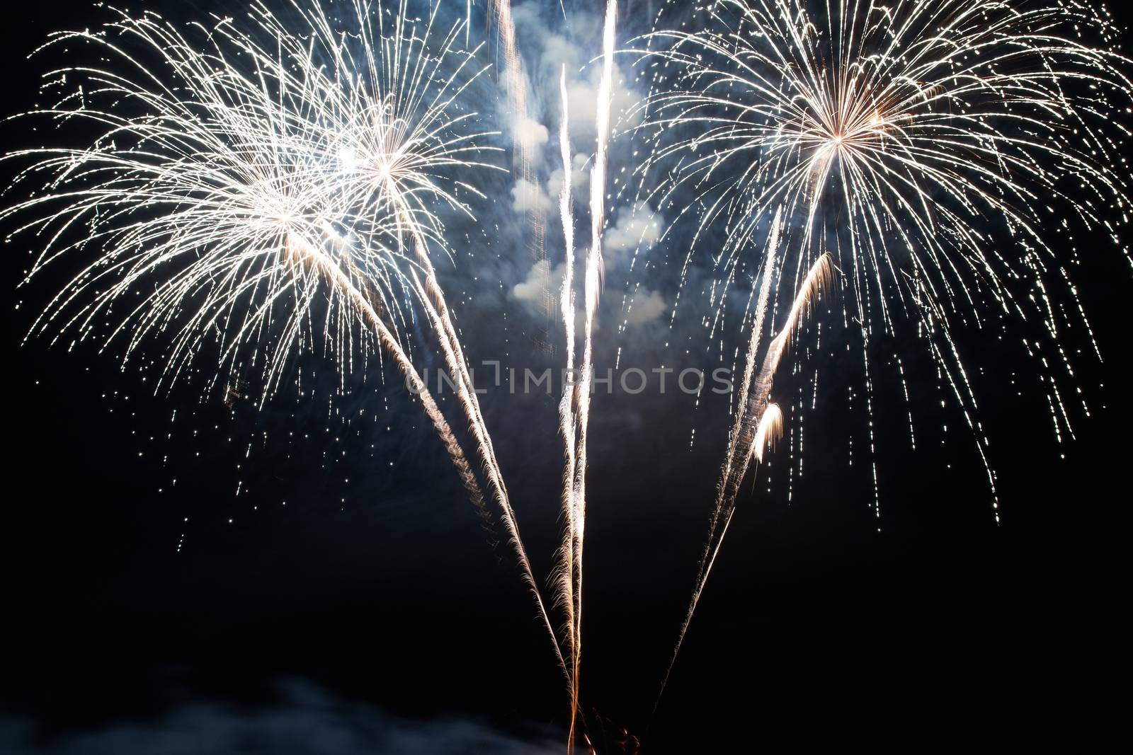 Red and purple colorful holiday fireworks on the black sky background.