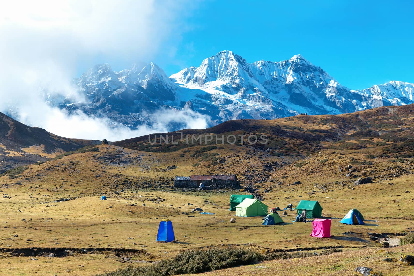 Campsite with tents on the top of high mountains, covered by snow. Kangchenjunga, India.