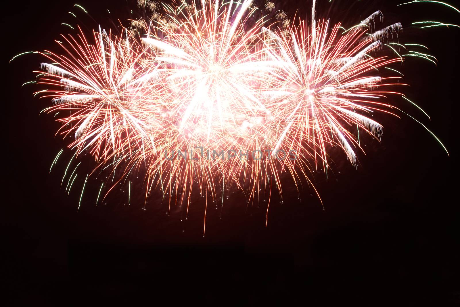 Red colorful holiday fireworks on the black sky background.