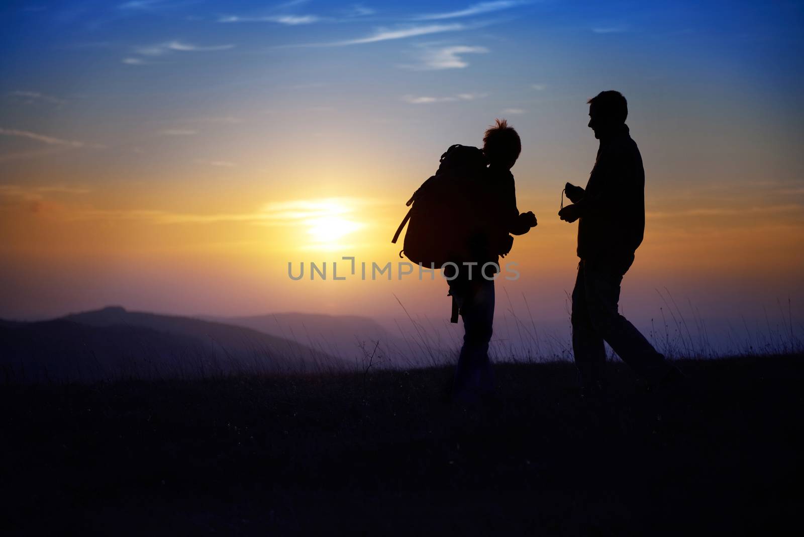 Silhouette of young couple against colorful sunset