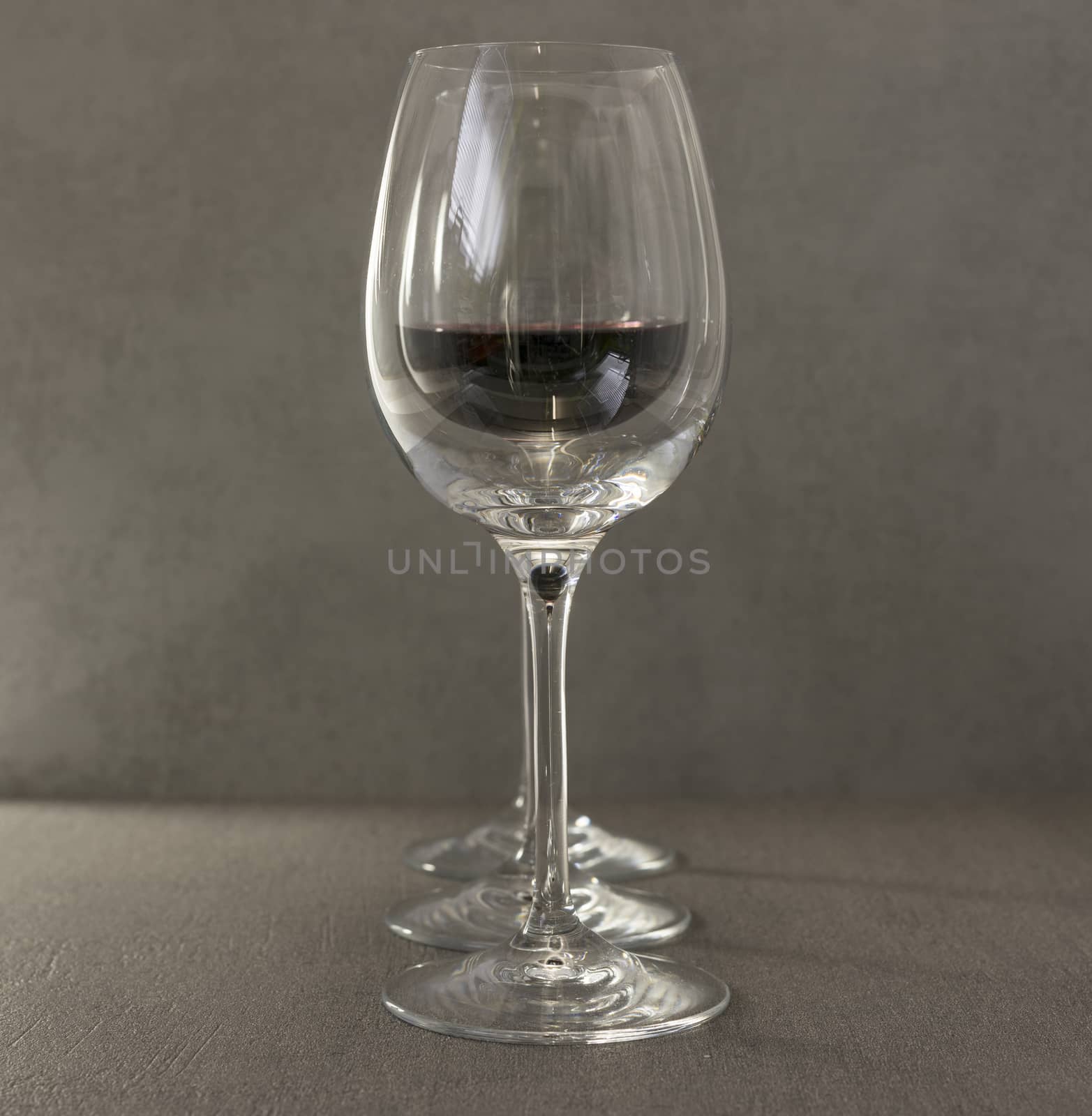 three wine glasses with red wine on dark gray background