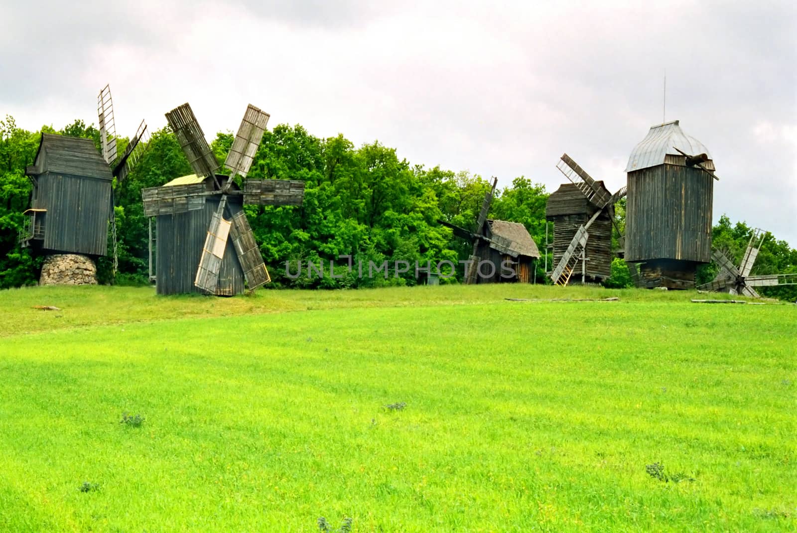 Wooden mills on the field of green grass. Kiev, Ukraine.