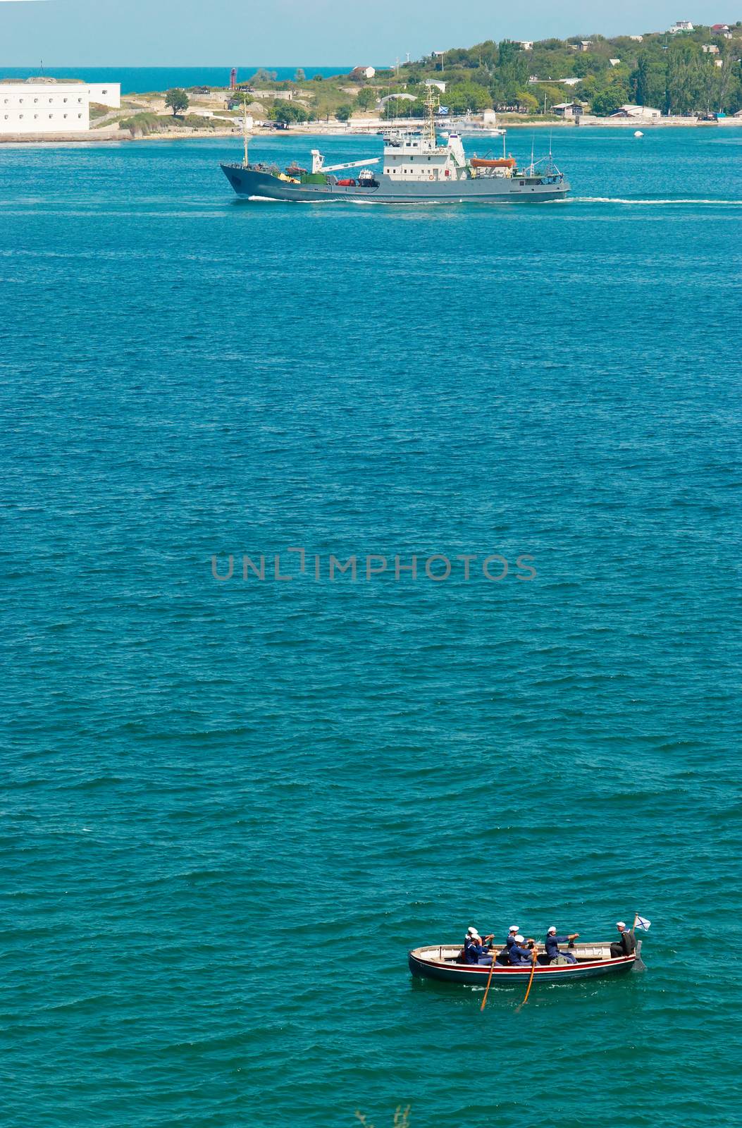 The warship and the boat with sailors.