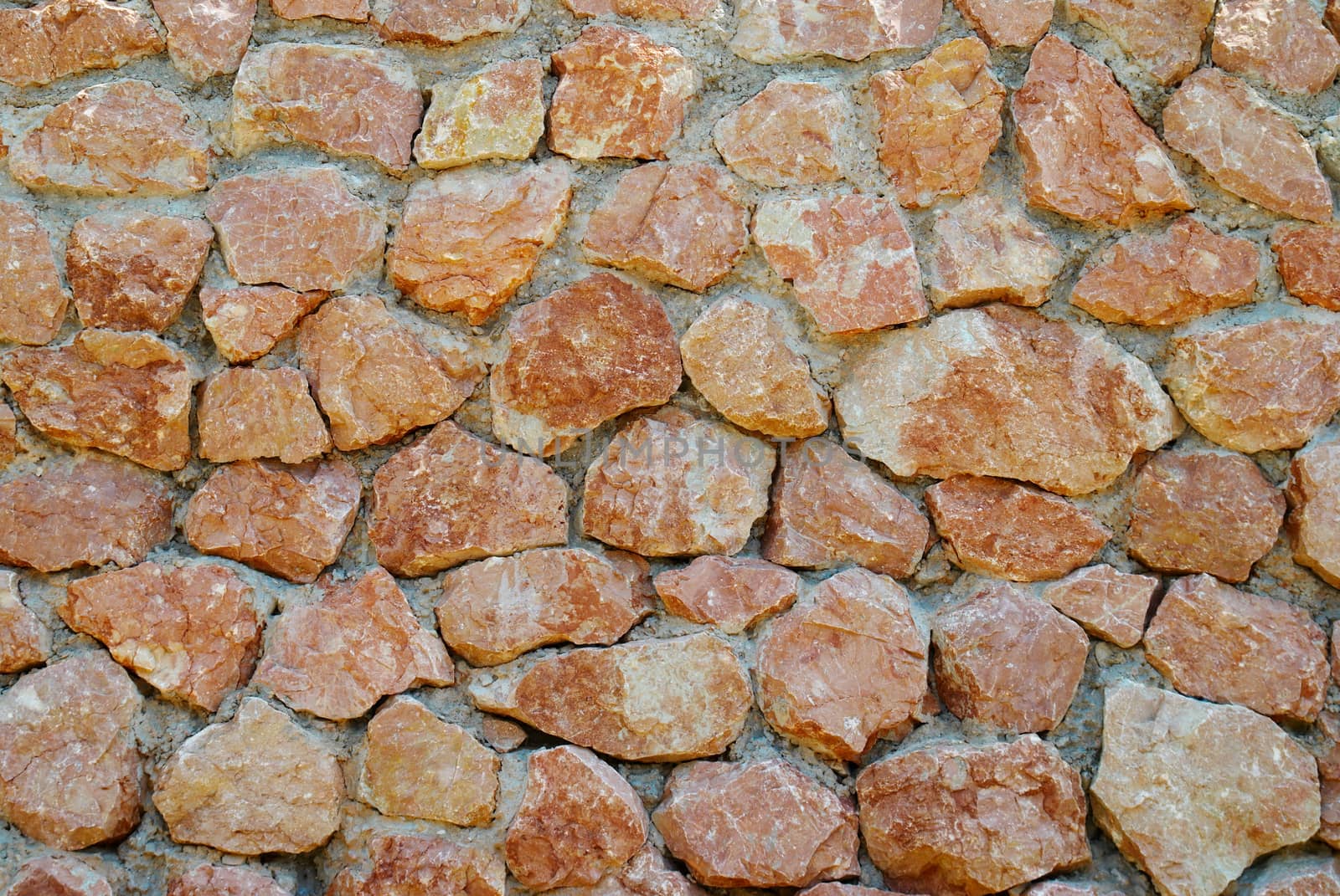 A wall of textured red stones.