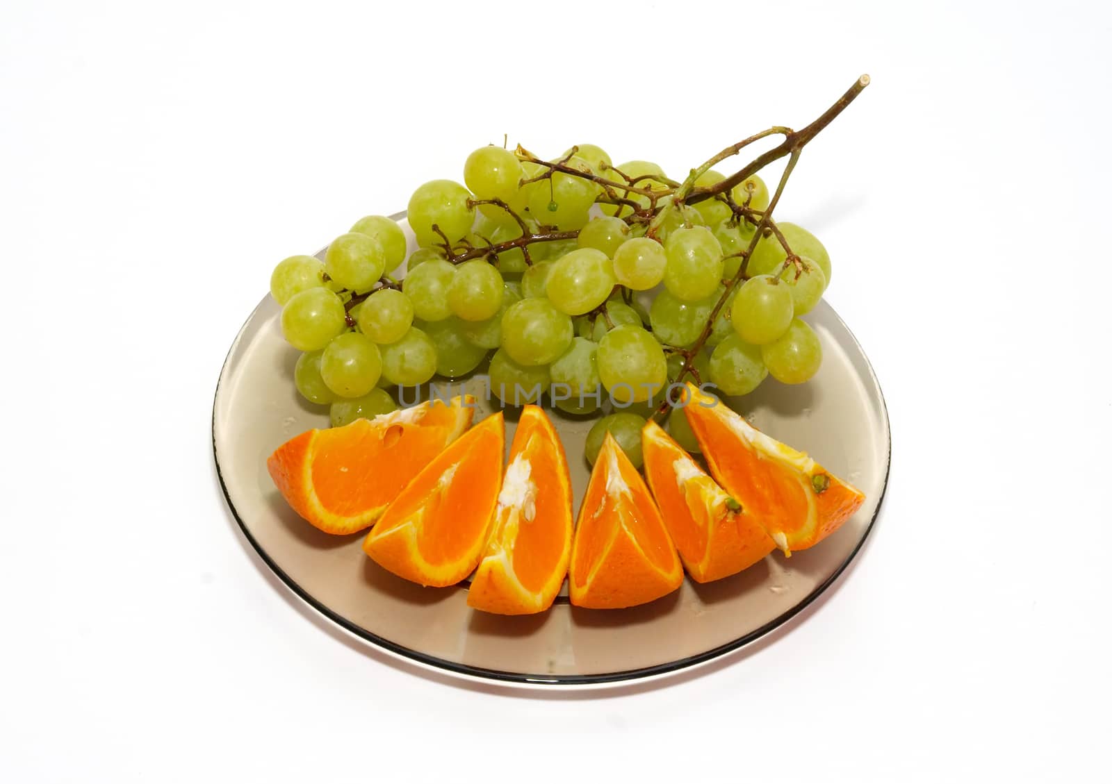 Green grapes and orange isolated on white.