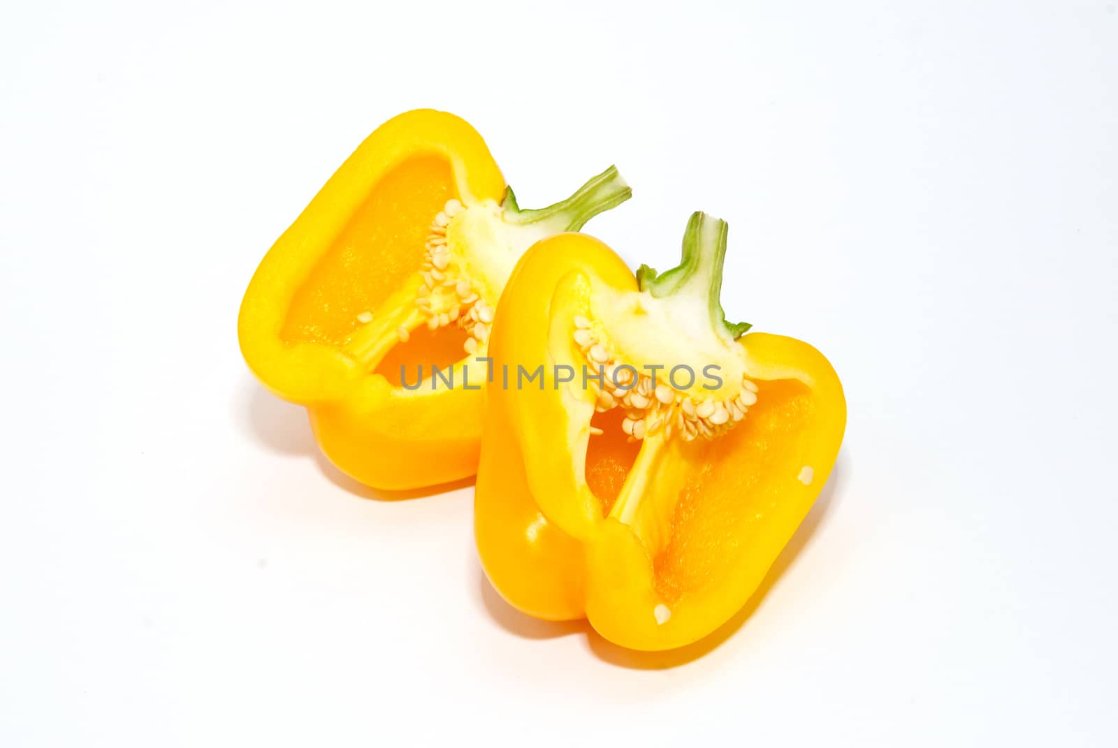 Two halves of slitting yellow paprika isolated on white. by vapi