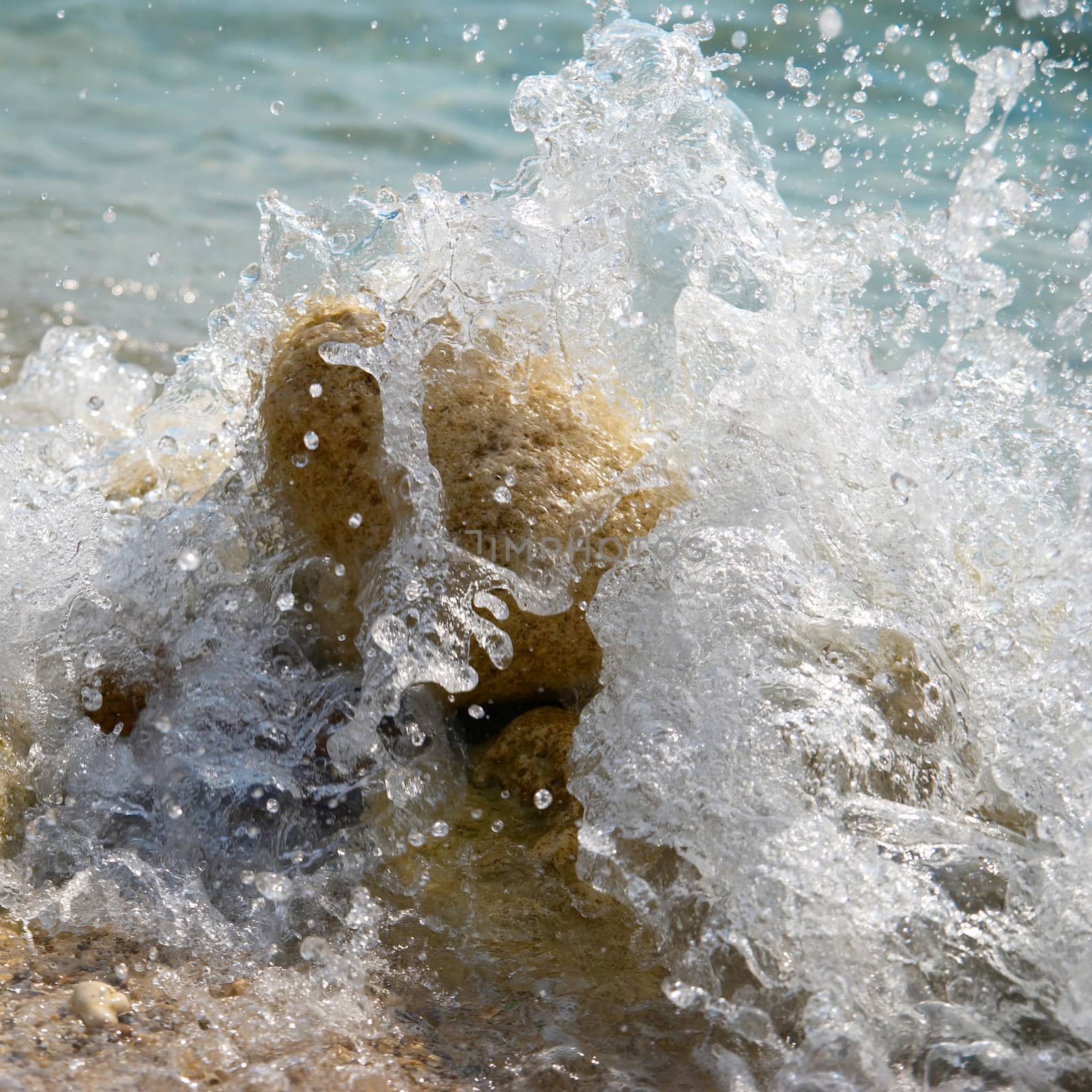 Rocks in the waves and sea foam.