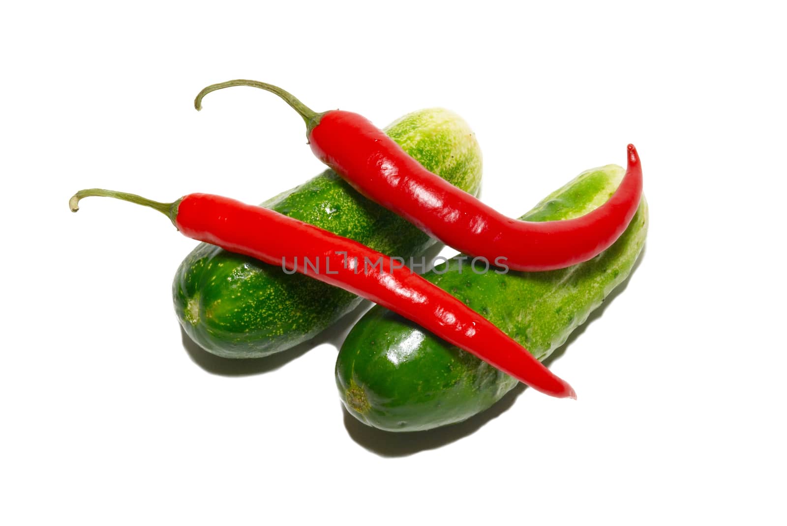 Cucumbers and red peppers isolated on white.