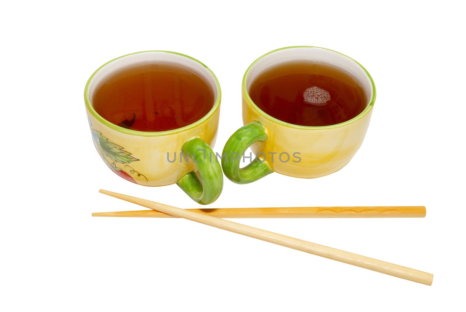 Two teacups with tea and chopsticks isolated on white.