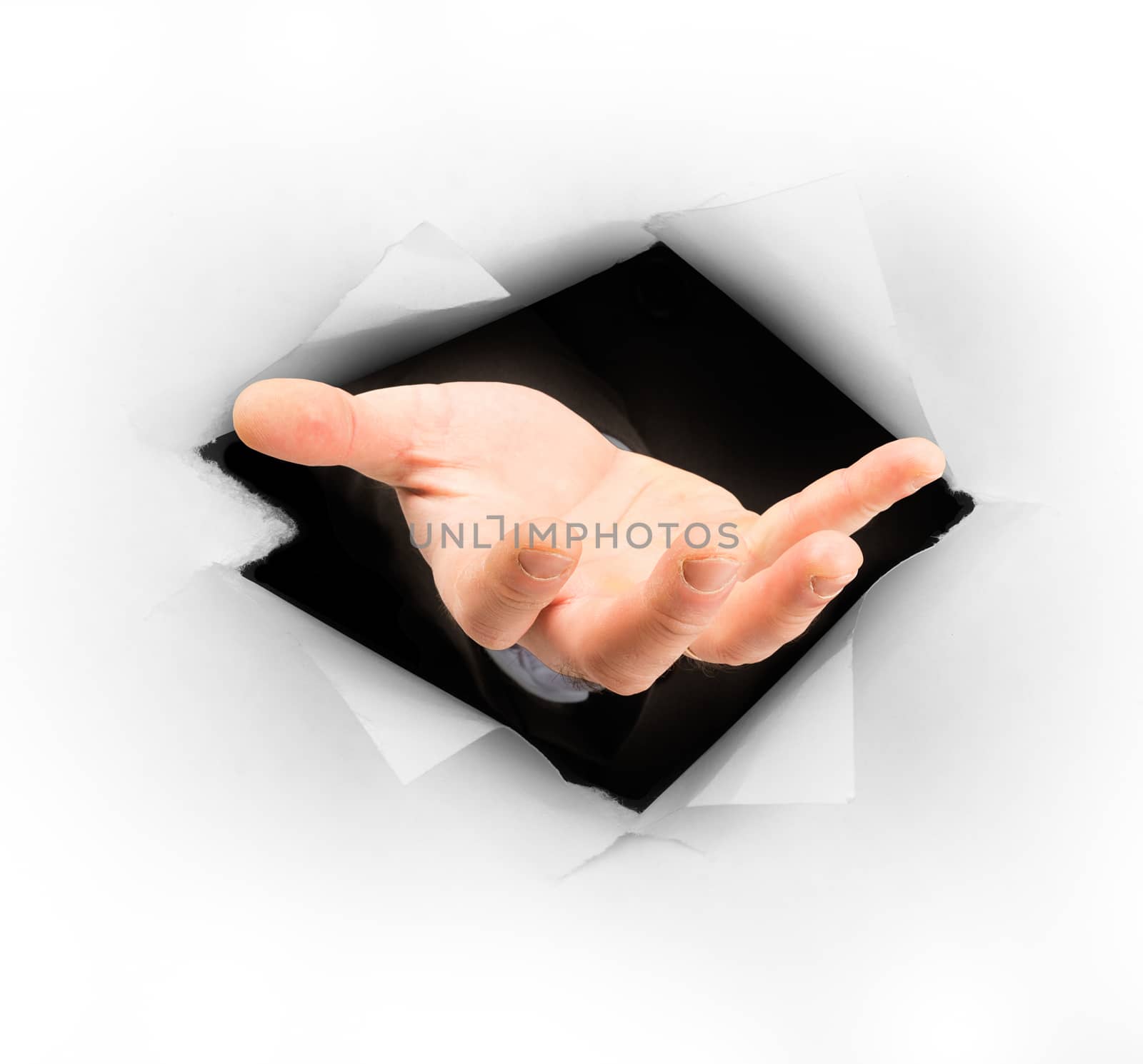Businessmans hand stretching out of hole in paper