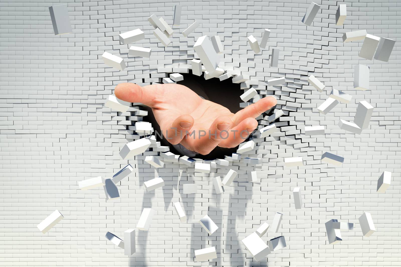 Businessmans hand stretching out of hole in brick wall