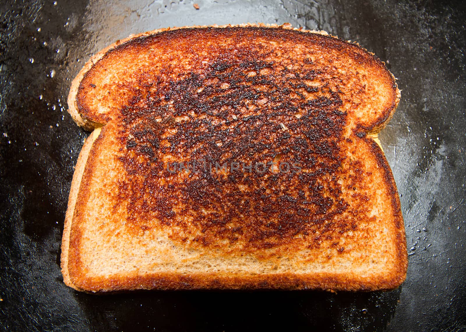 Grilled cheese sandwich that has a slightly burnt look to it