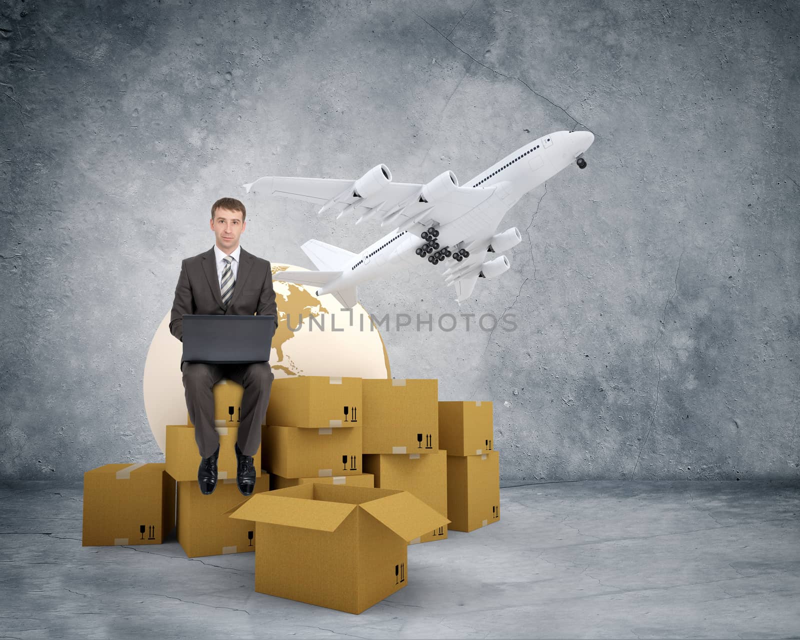 Businessman working on laptop and sitting on pile of boxes and jet