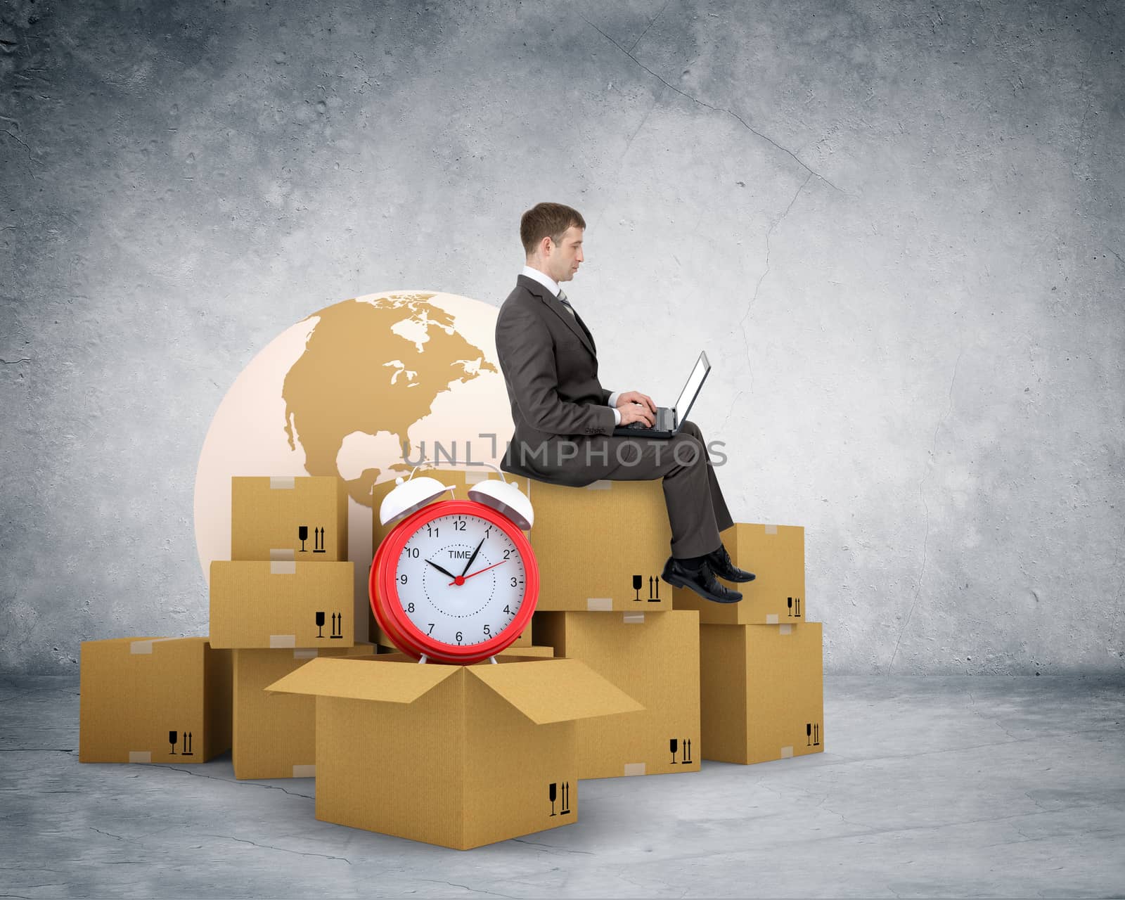 Businessman working on laptop and sitting on pile of boxes