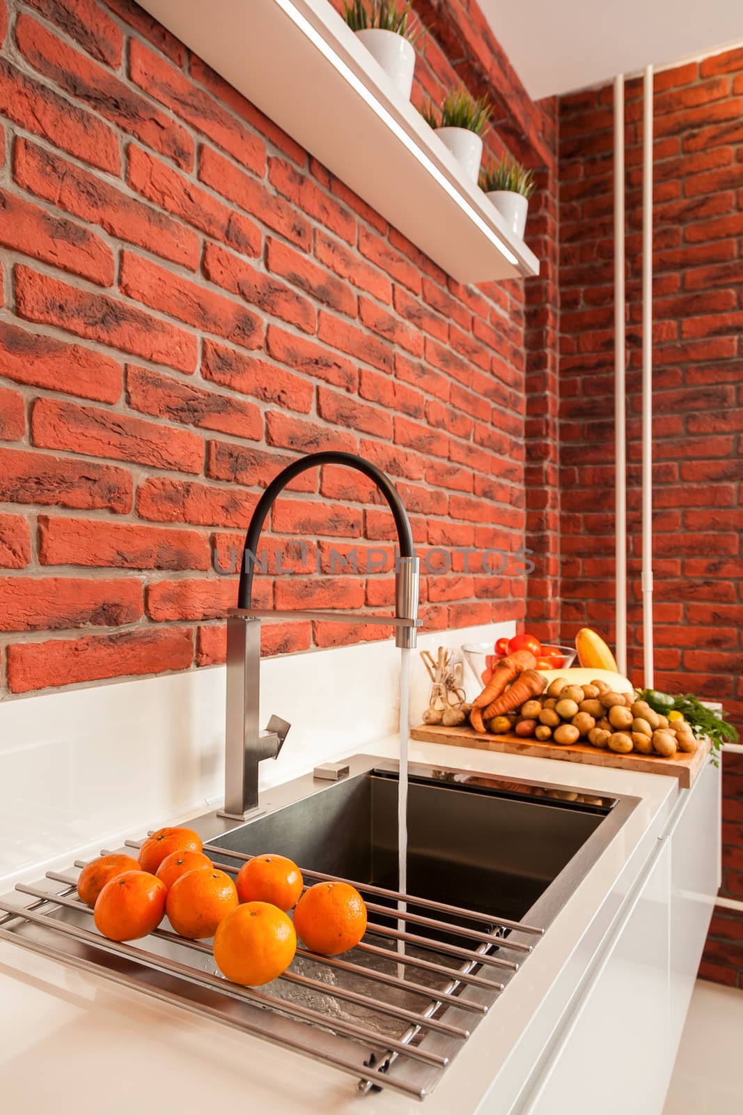 the steel mixer with a sink and vegetables in magnificent modern kitchen