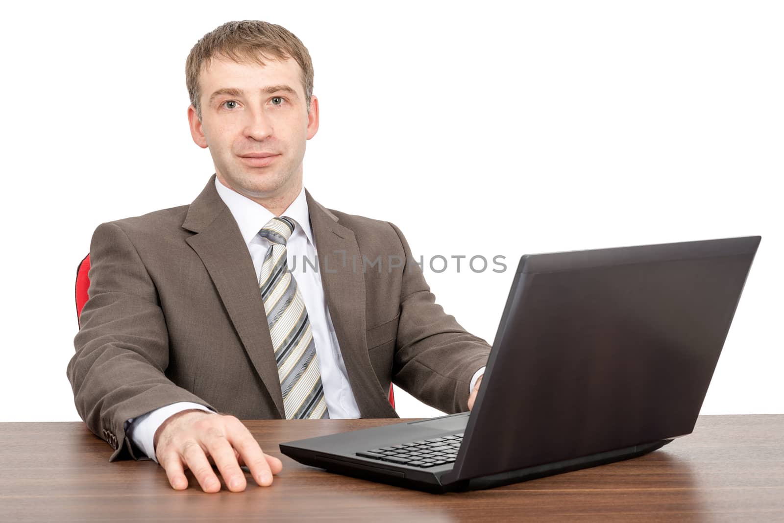 Businessman working on laptop and looking at camera isolated on white background, front view