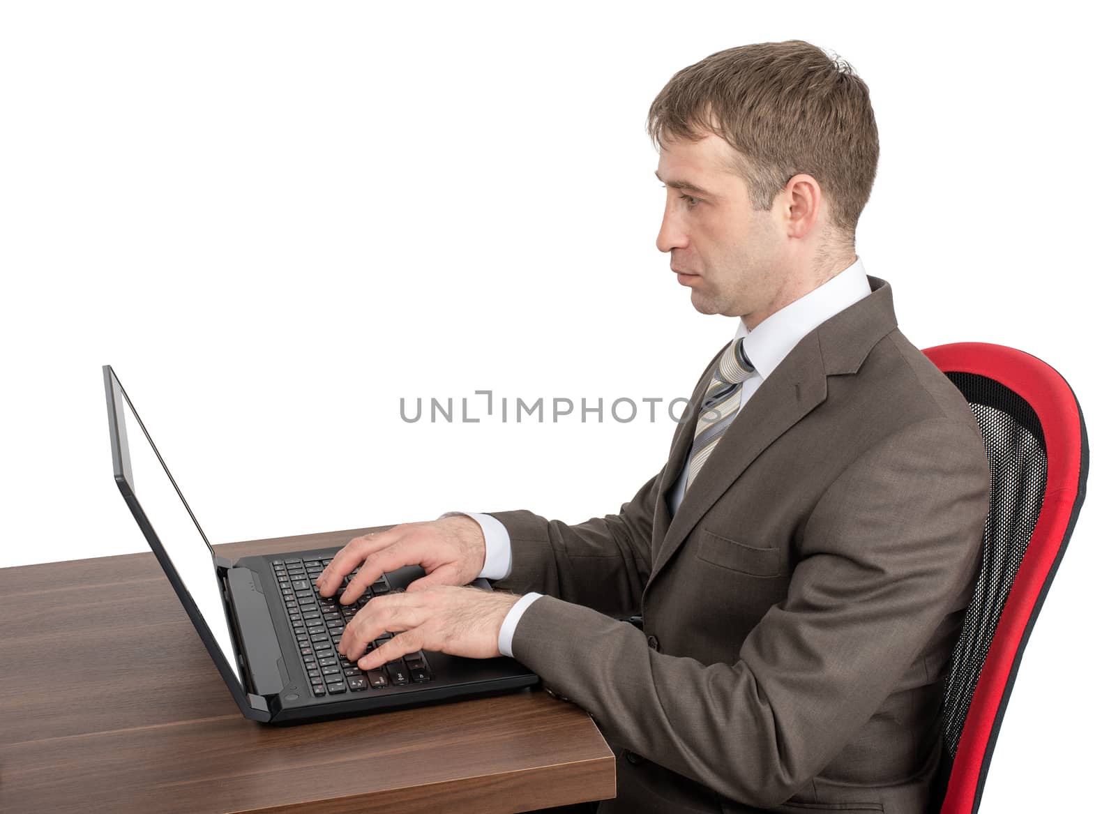 Businessman working on laptop at table isolated on white background, side view