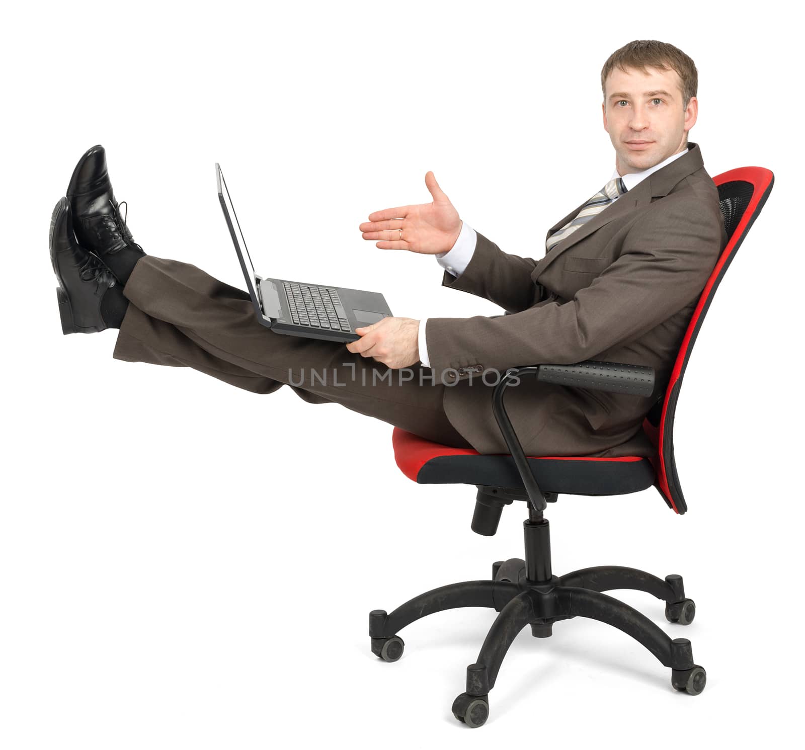 Businessman sitting on chair with laptop and legs up, looking at camera isolated on white background