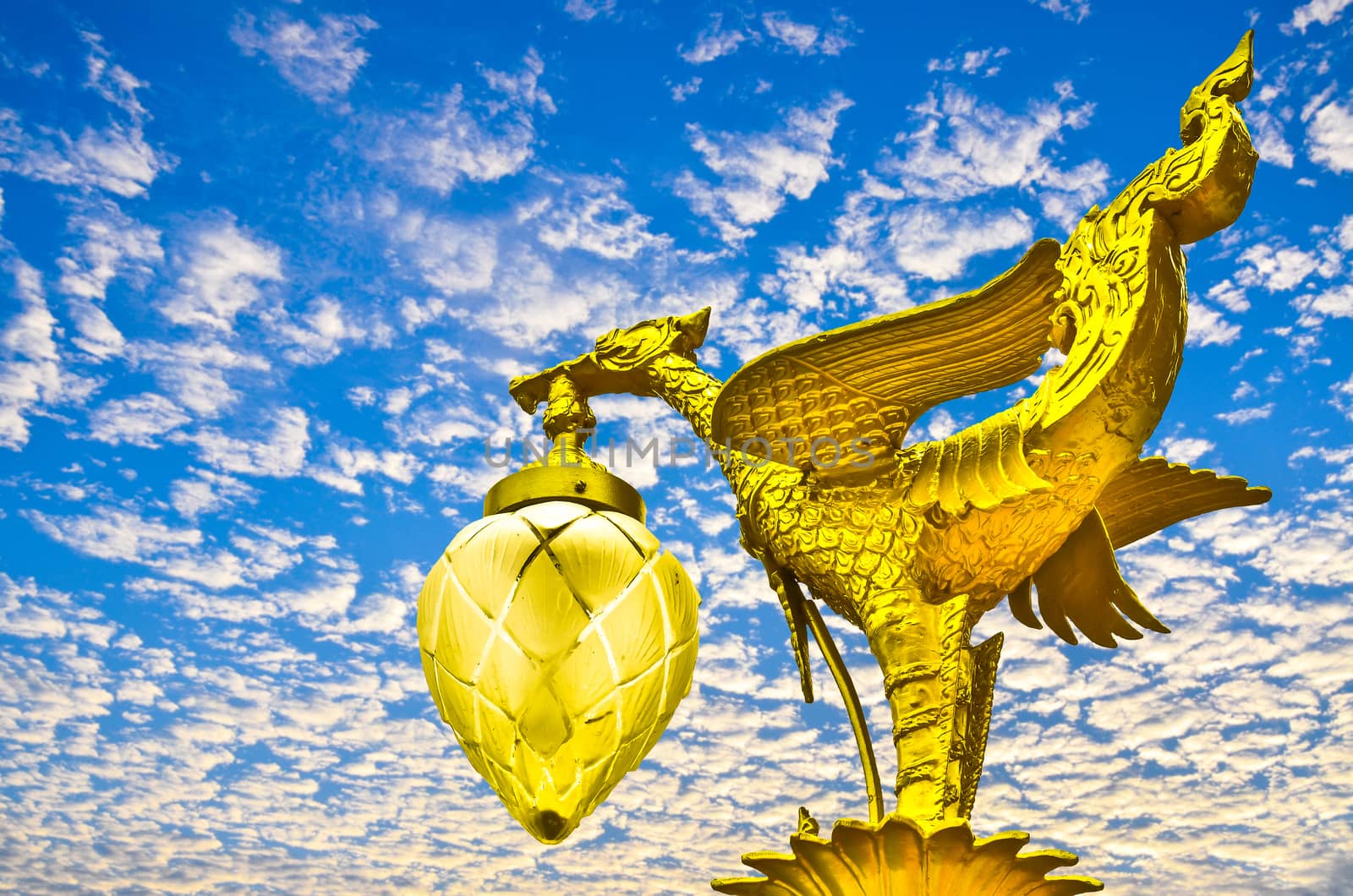 Golden swan sculpture on blue sky
