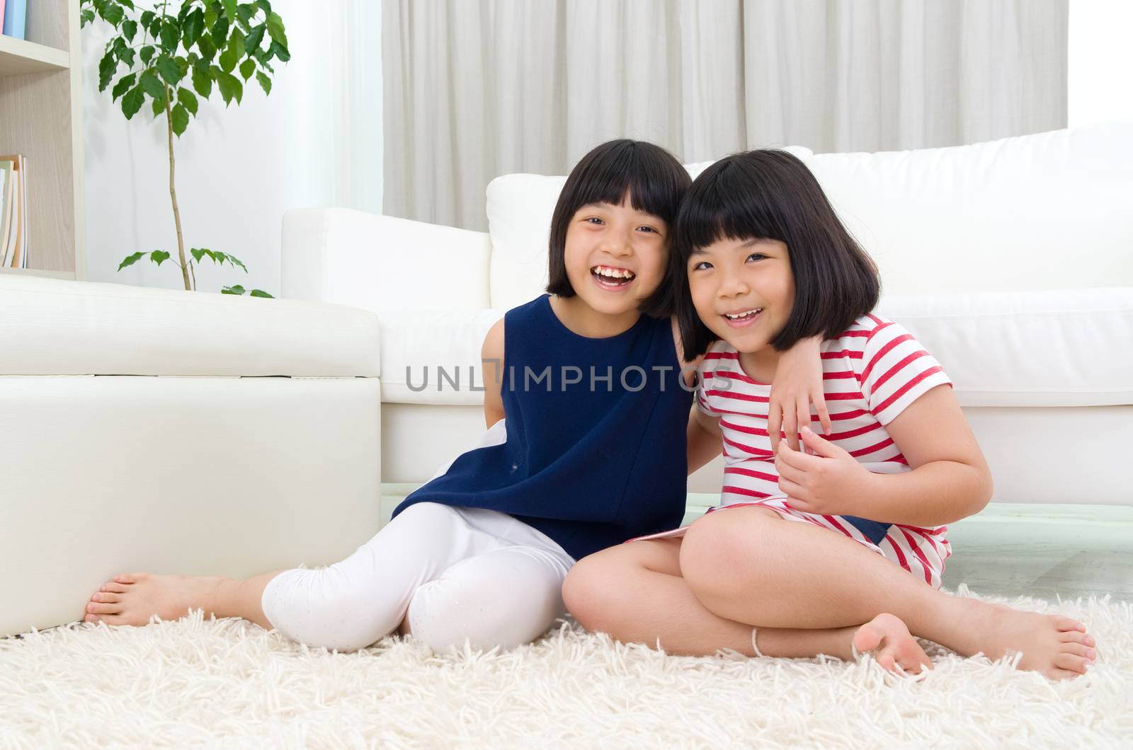 Asian sisters sitting on the floor