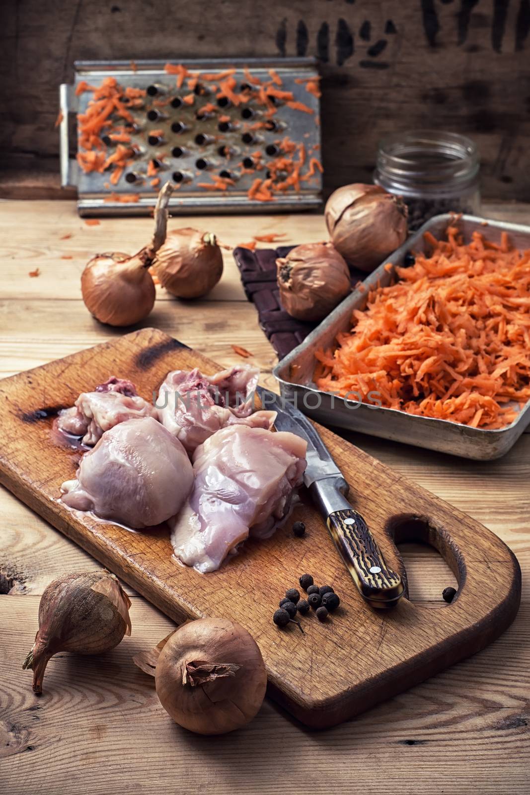 raw fillet of chicken meat and onions in the process of cooking food