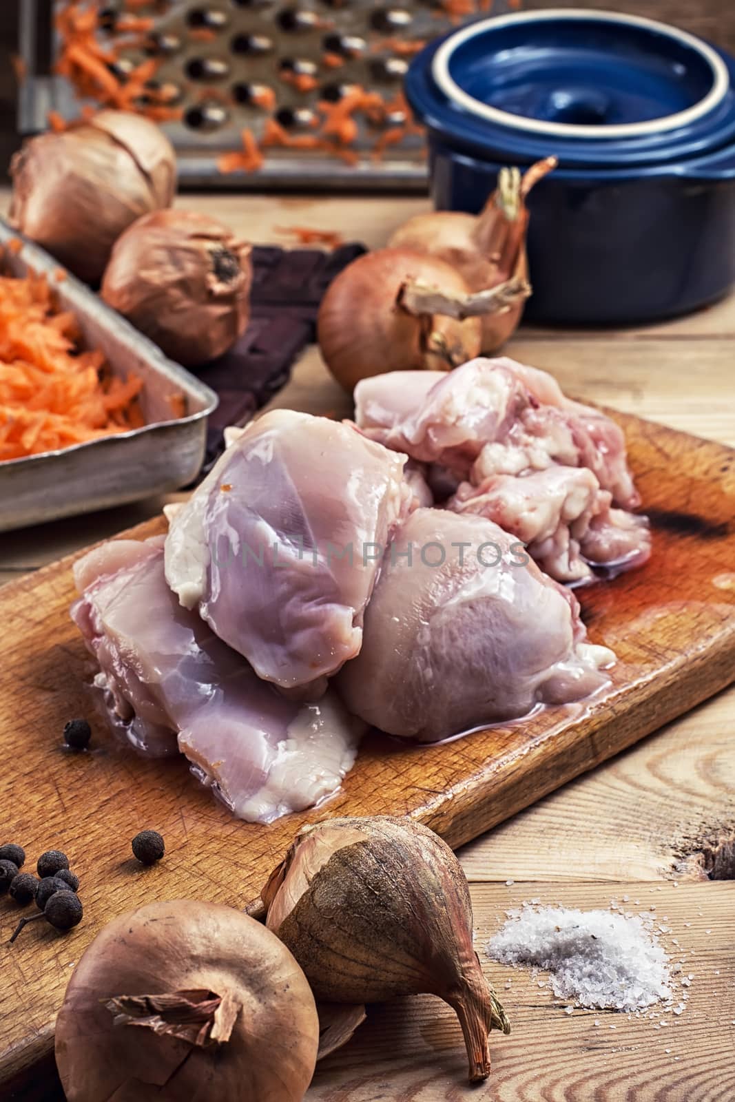 raw fillet of chicken meat and onions in the process of cooking food