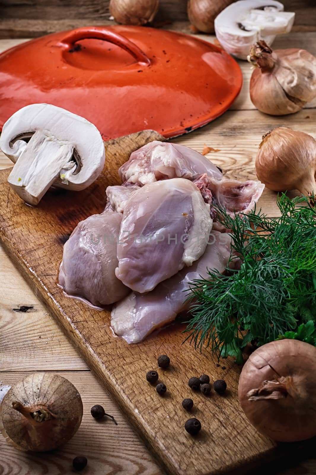 raw fillet of chicken meat and onions in the process of cooking food