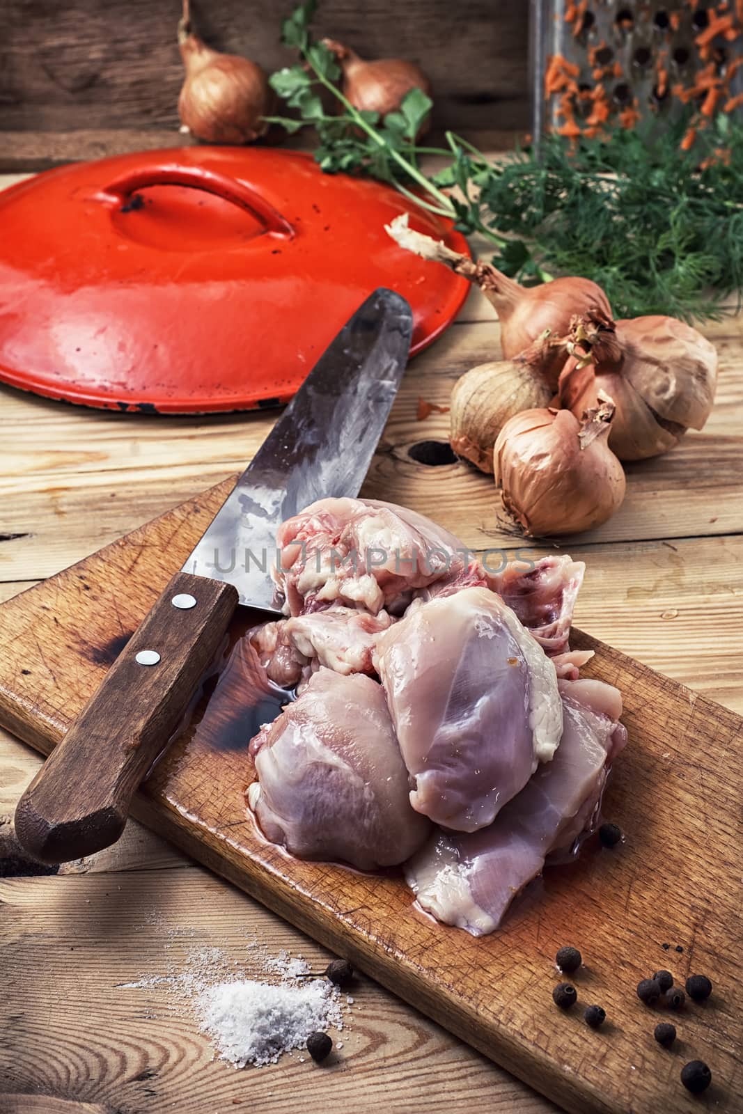 raw fillet of chicken meat and onions in the process of cooking food