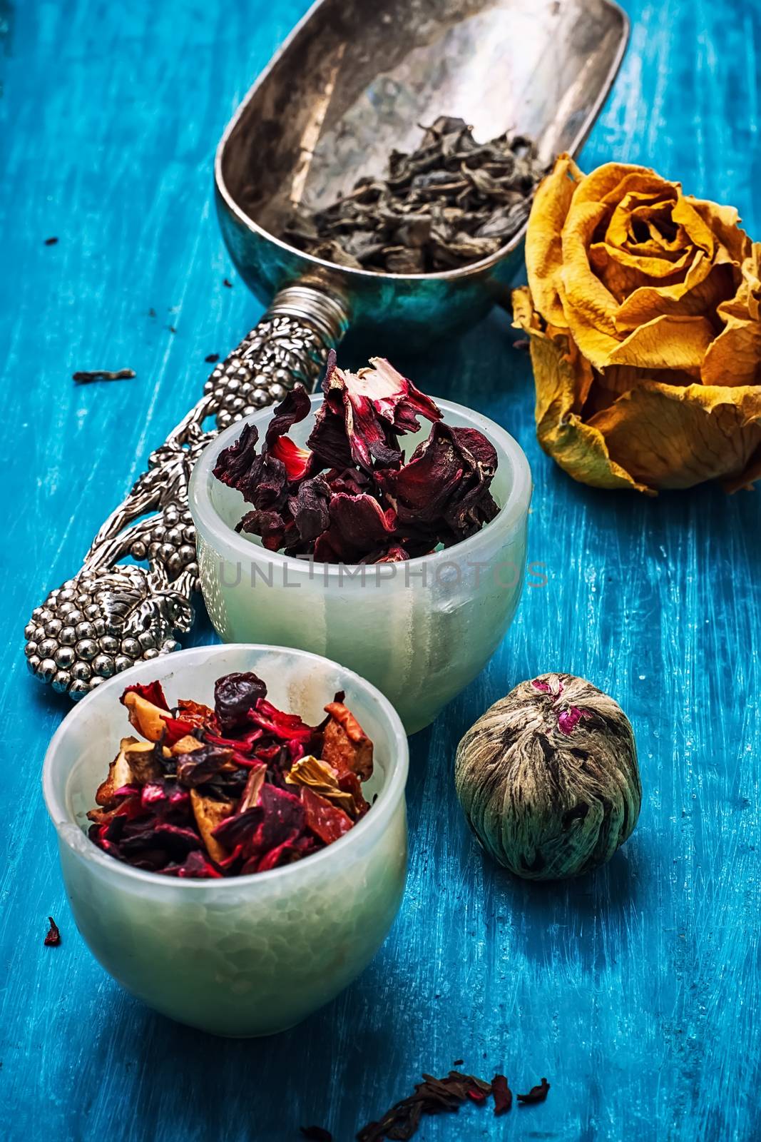 dried fragrant tea leaves on wooden turquoise background.Shallow DOF