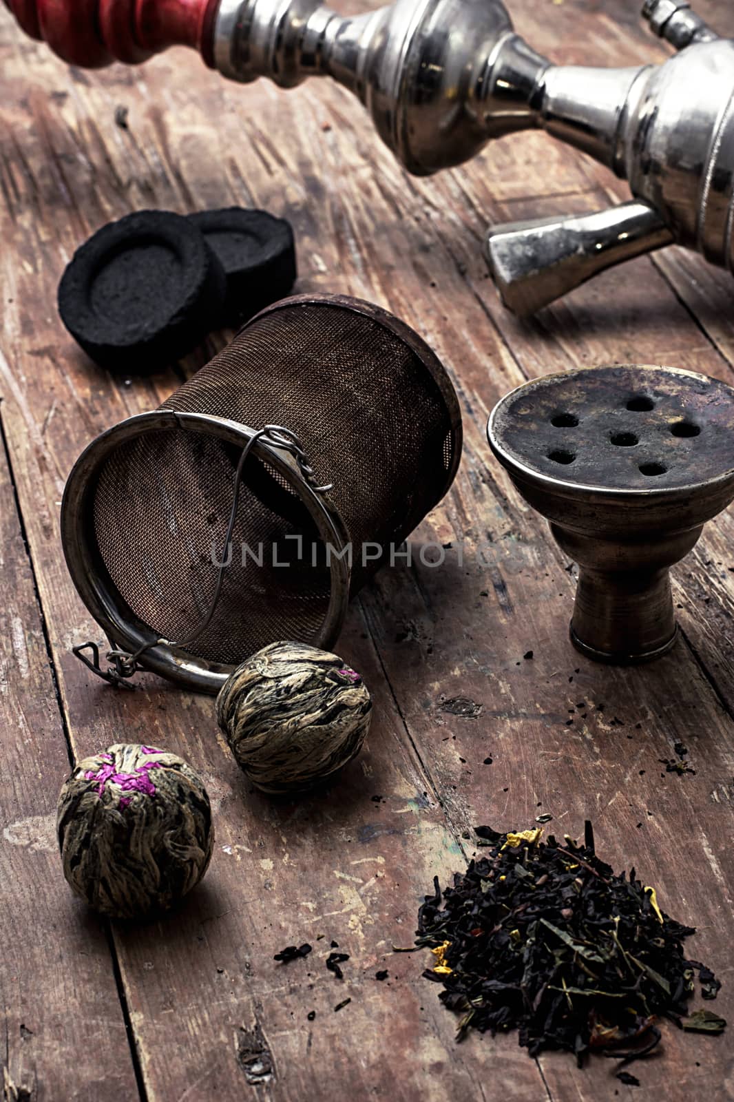 details hookah and dry elite tea leaves on wooden background.The toned image