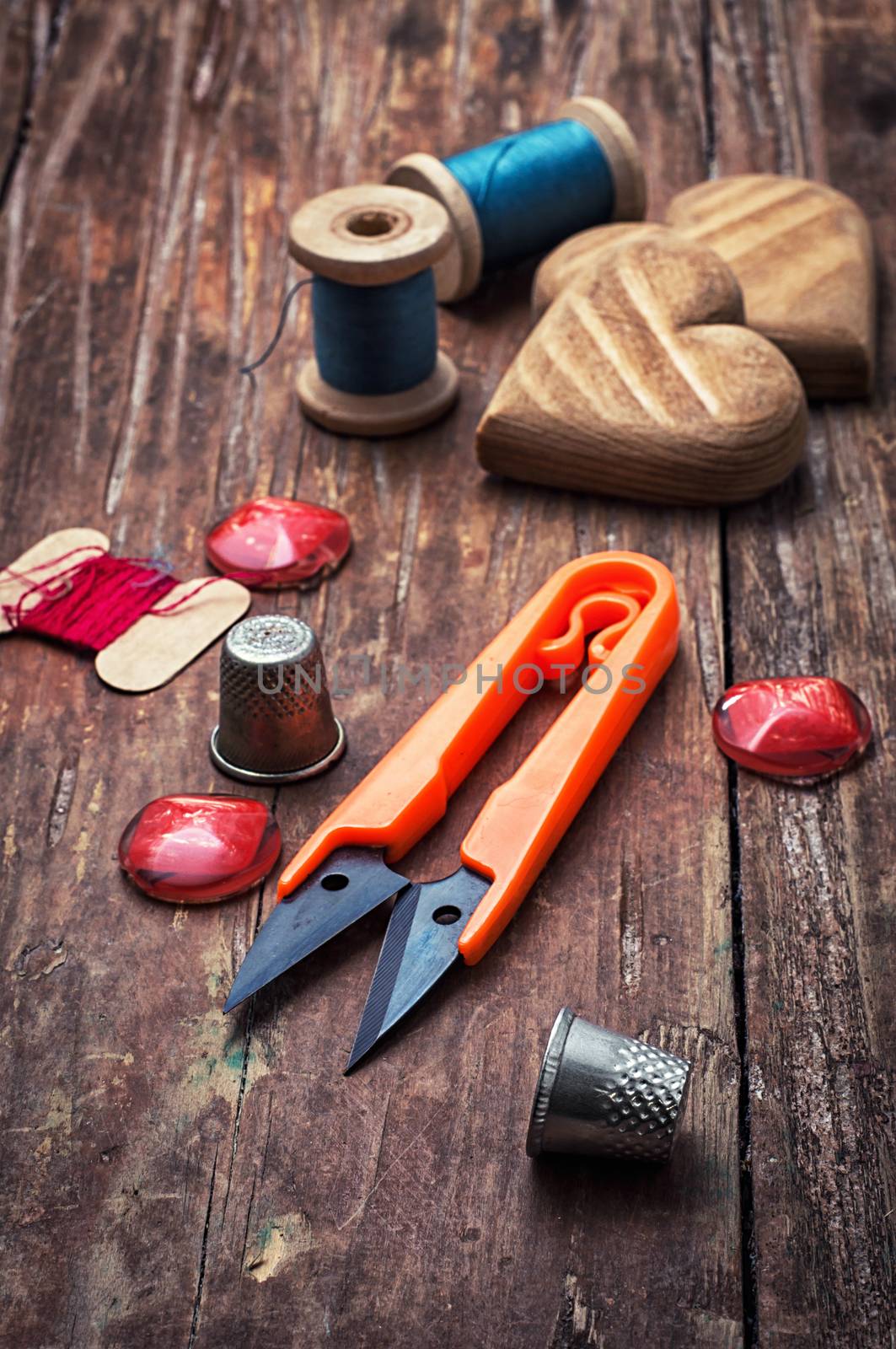 tools seamstresses on wooden background.the image is tinted in vintage style