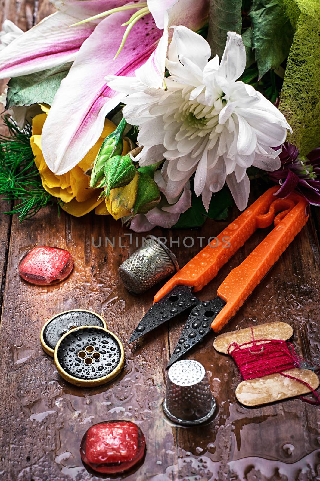 sewing accessories with a bouquet of fresh flowers.the image is tinted in vintage style