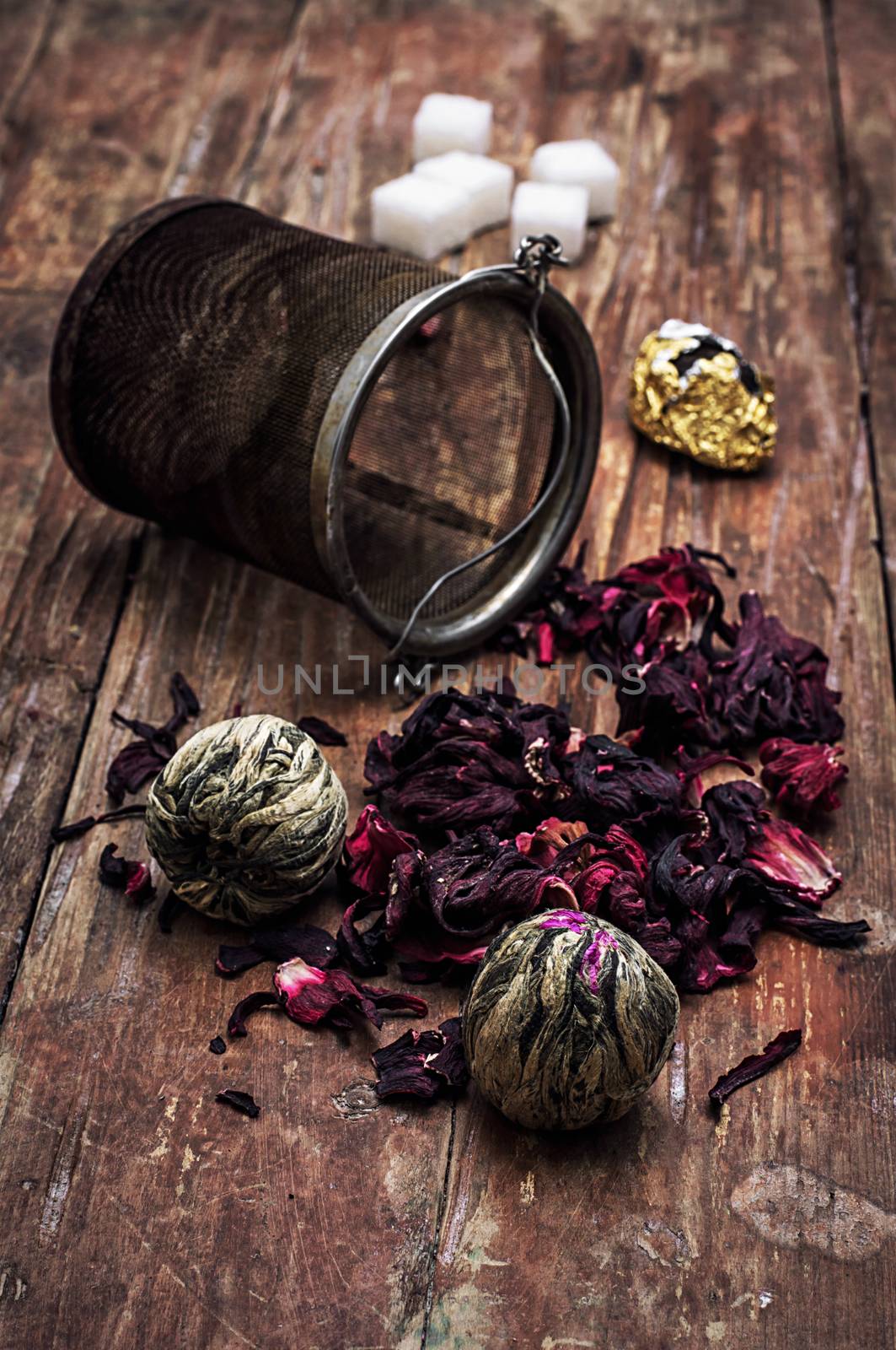 tea strainer and different varieties of tea leaves on wooden background.The toned image