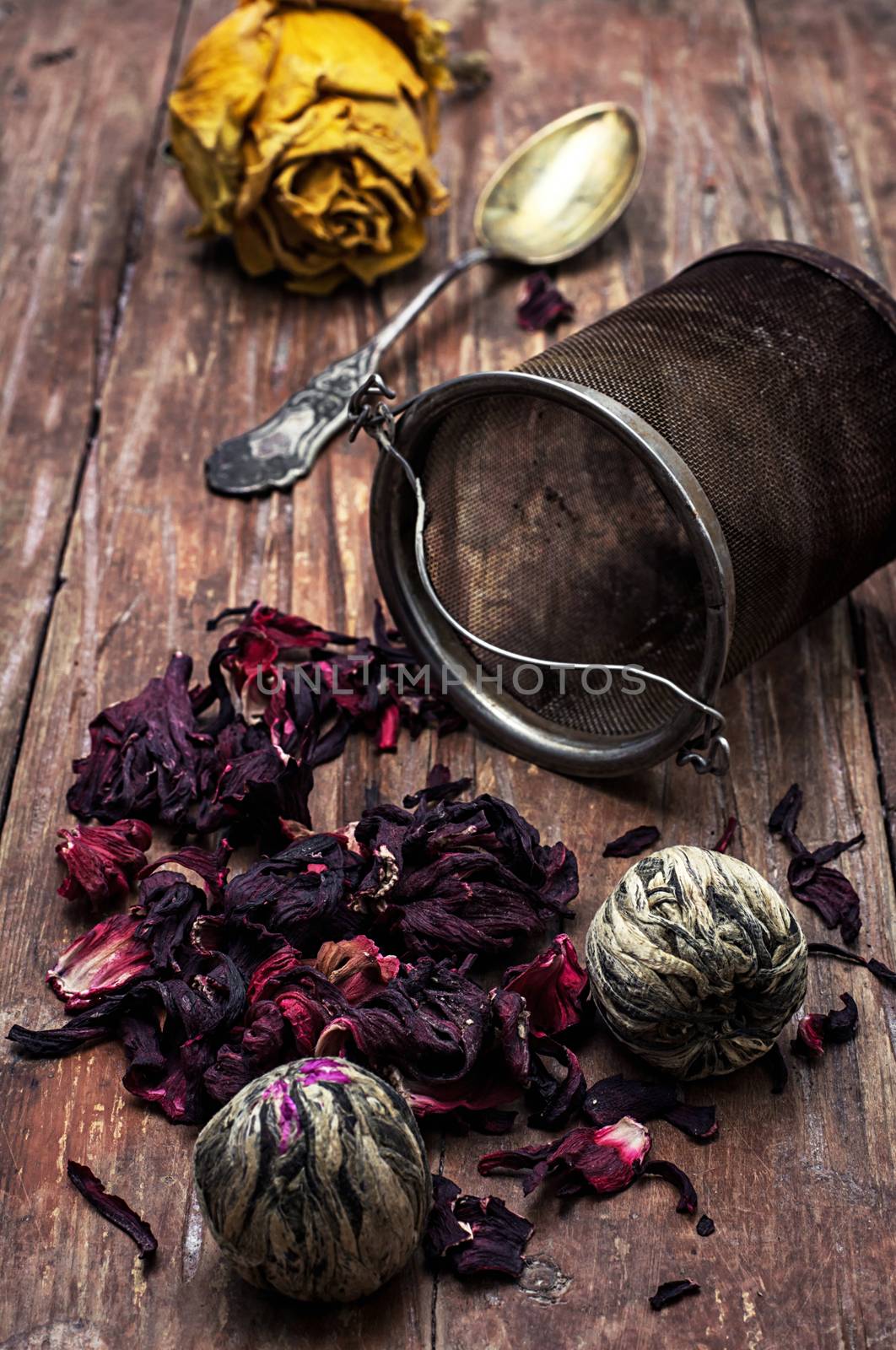 tea strainer and different varieties of tea leaves on wooden background.The toned image