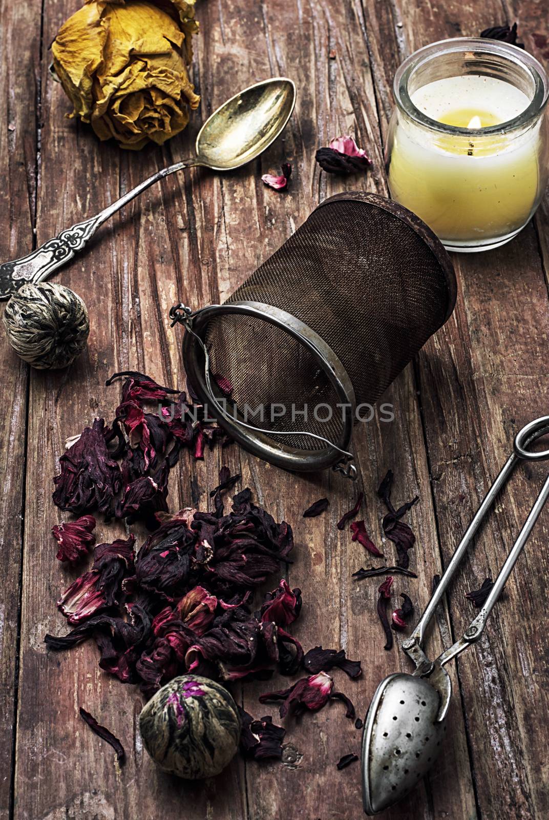 tea strainer and different varieties of tea leaves on wooden background.The toned image