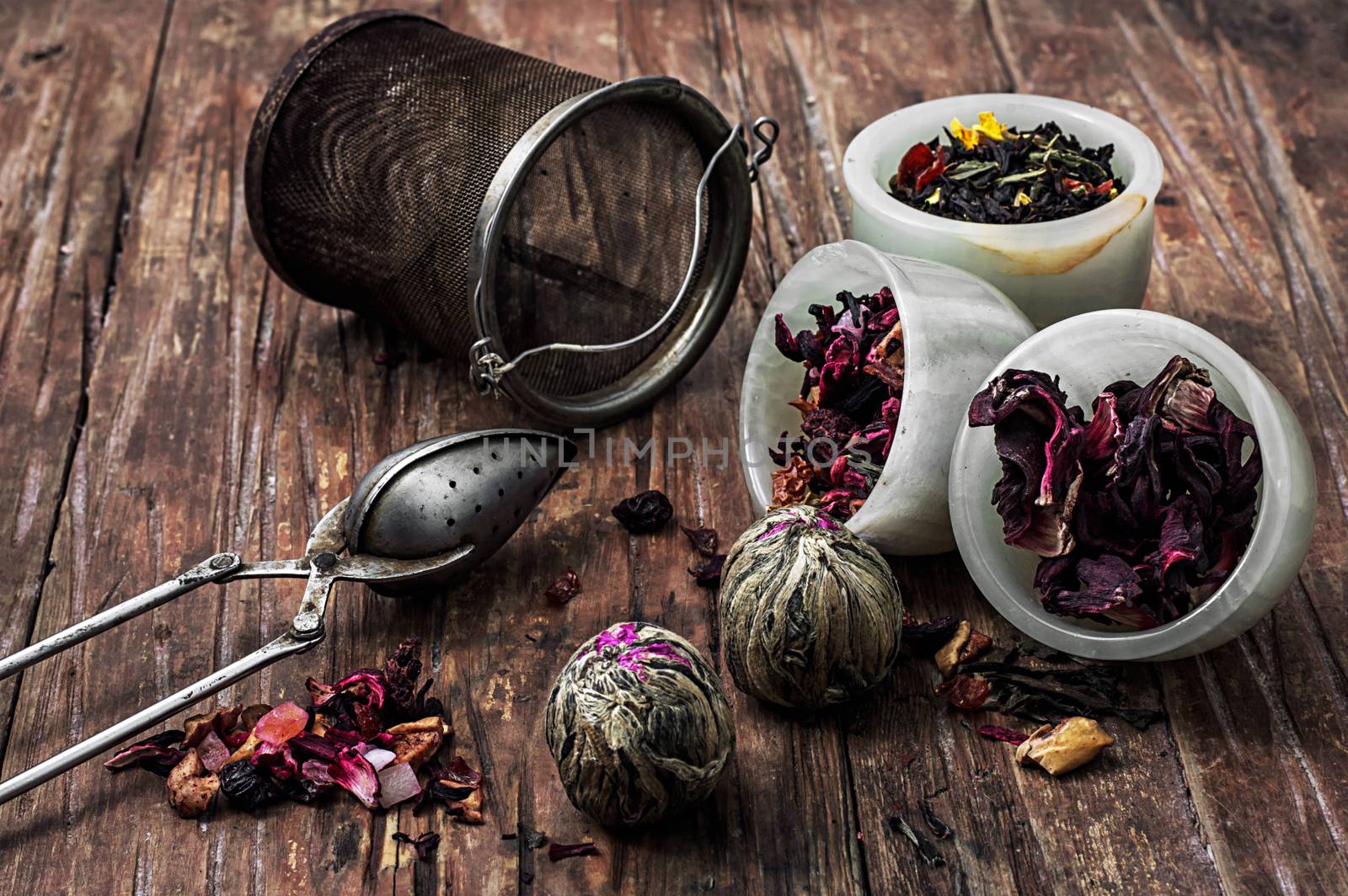 tea strainer and different varieties of tea leaves on wooden background.The toned image