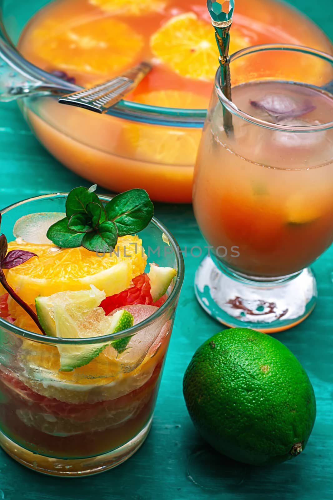 fresh juice from oranges,kiwi and grapefruit on turquoise wooden background.Selective focus