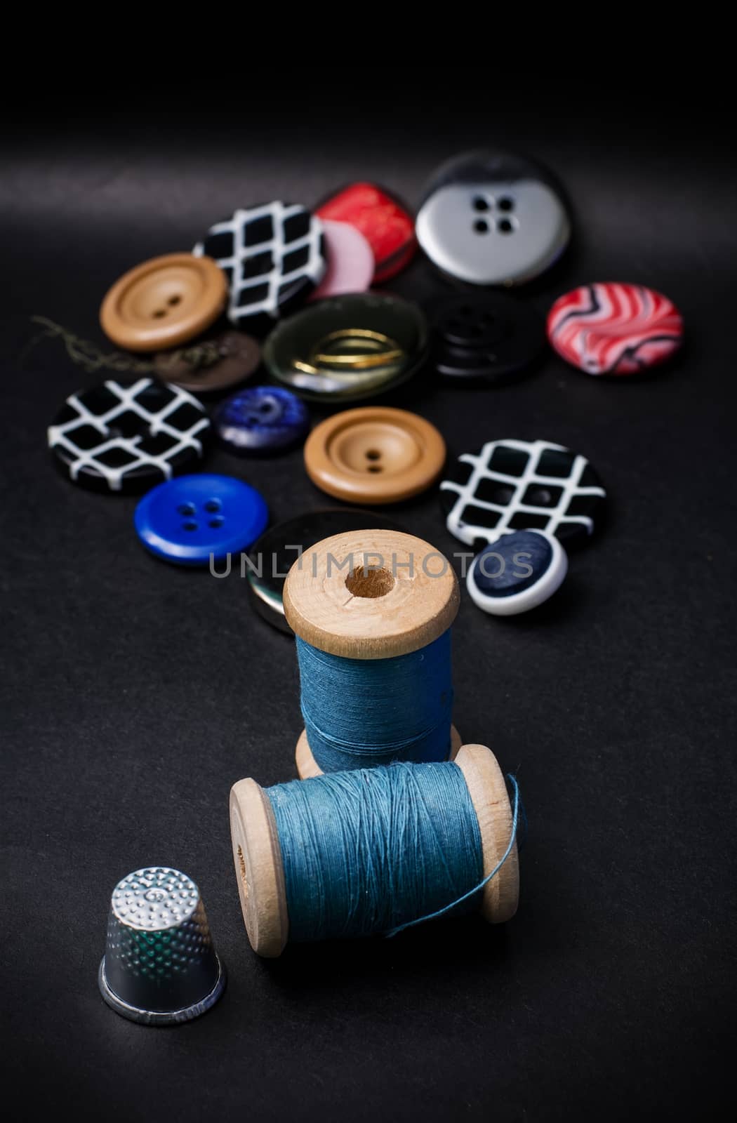 thread and buttons for sewing master on black background.Selective focus